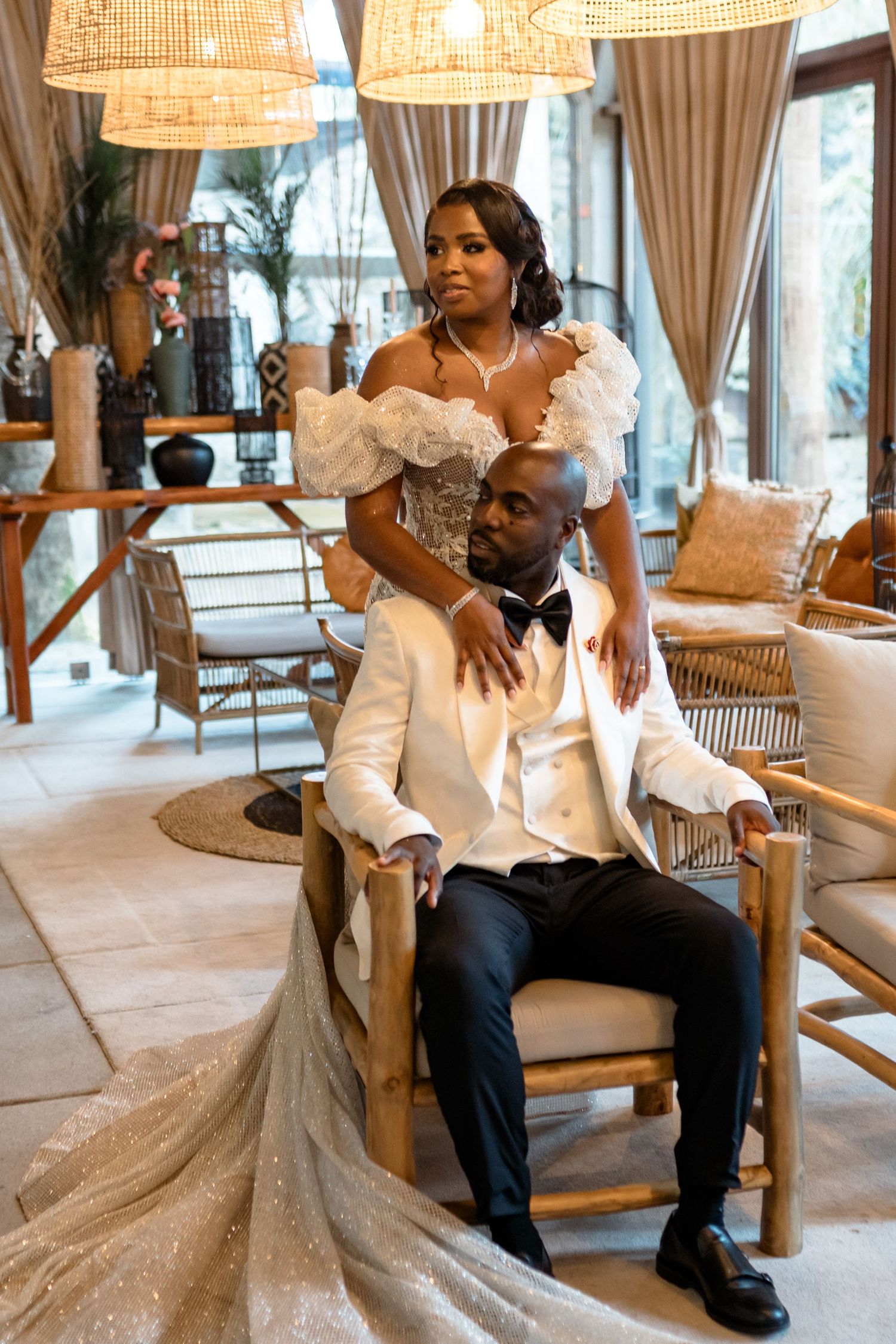 A romantic wedding portrait featuring a couple in white attire in an elegant indoor setting.