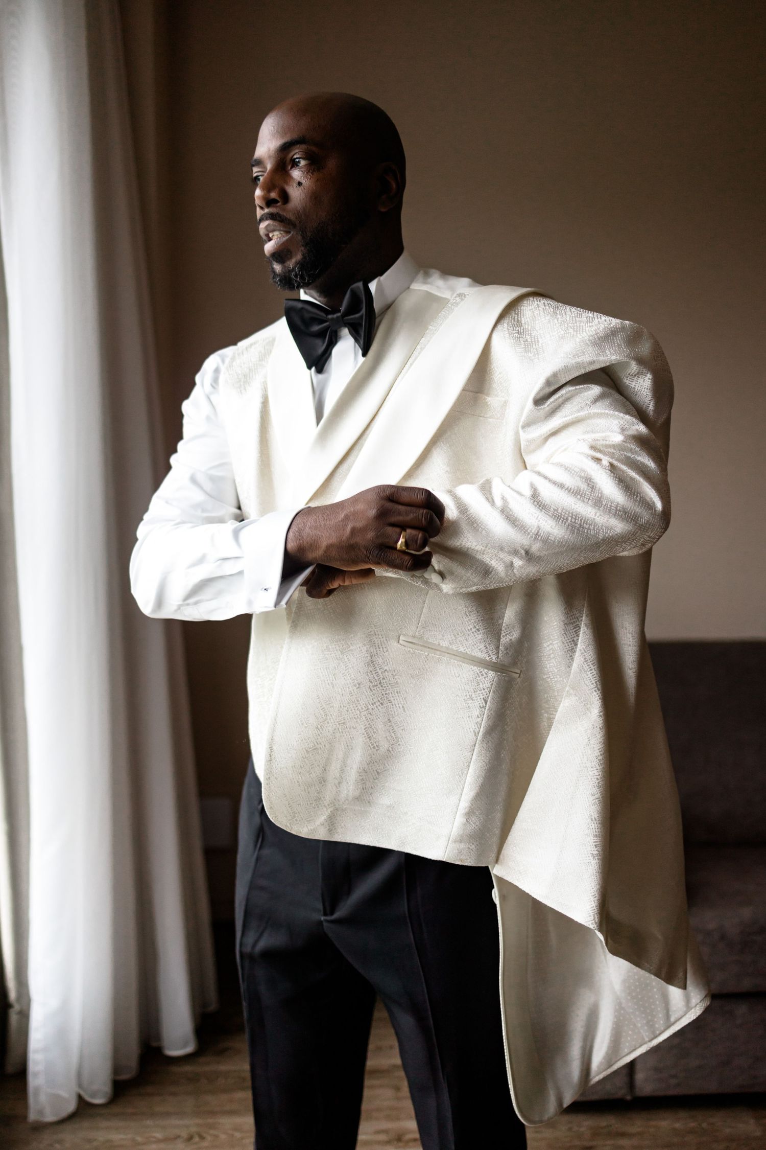 Formal portrait series featuring a white tuxedo jacket against window light.
