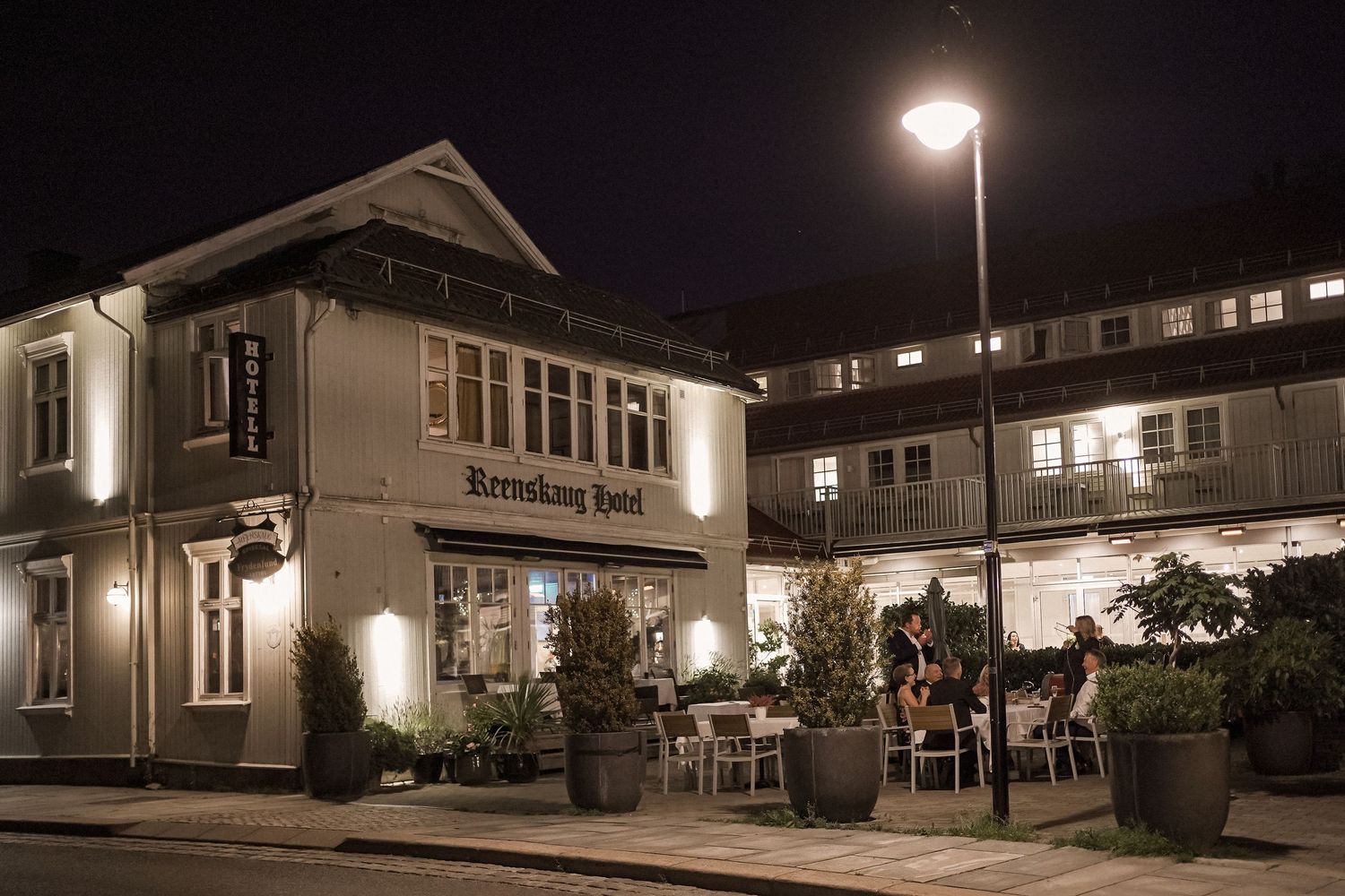 Nighttime exterior view of an illuminated wedding venue with classic architecture.