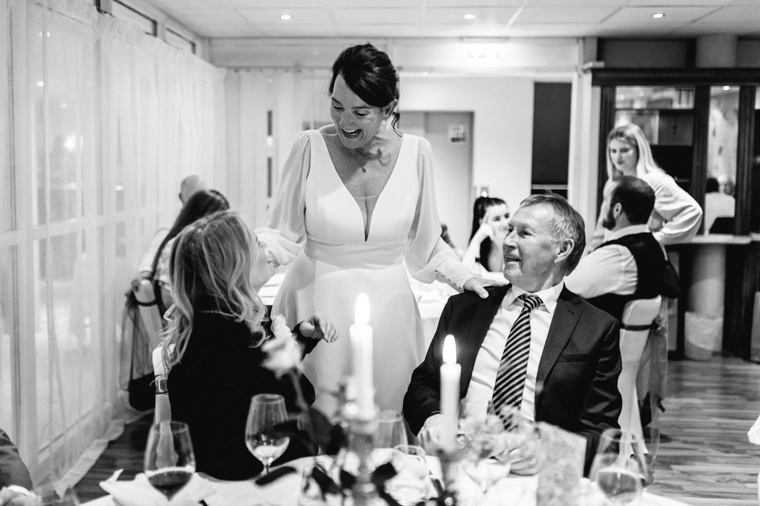 Black and white candid shots of wedding reception guests mingling at dinner tables.