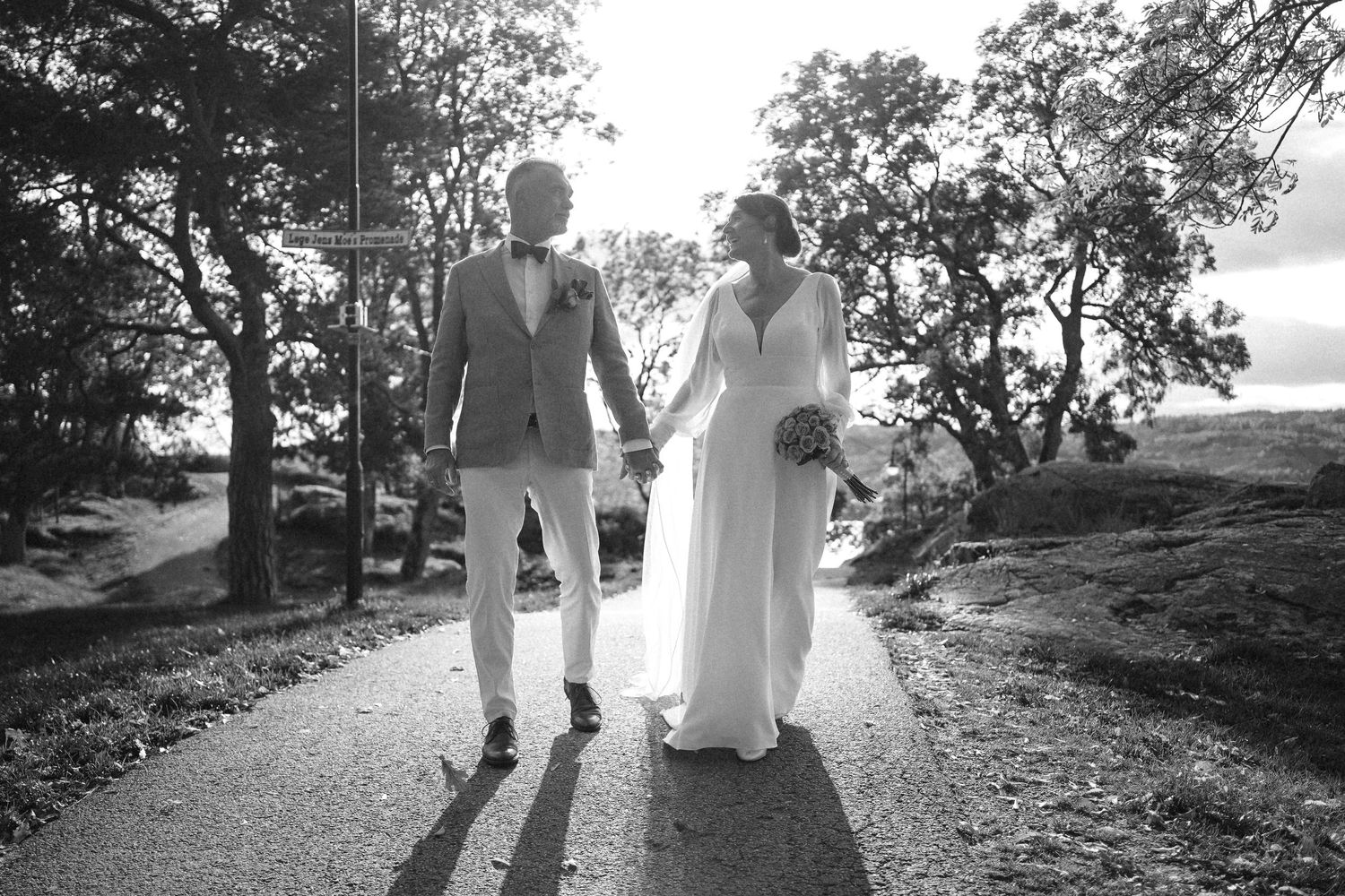 Couple walking along a scenic outdoor path during golden hour.