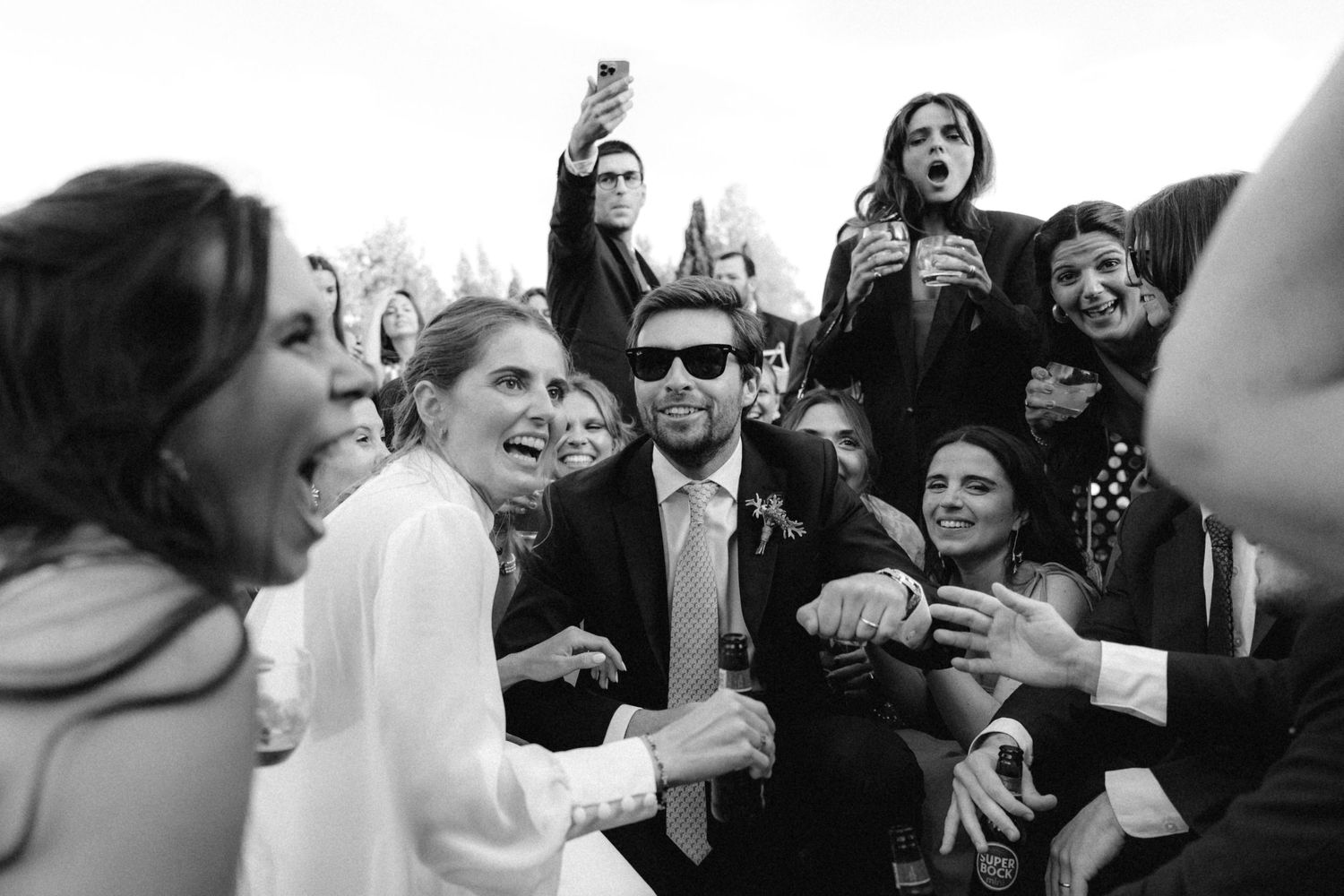 Wedding guests laugh and celebrate during a joyful reception party.
