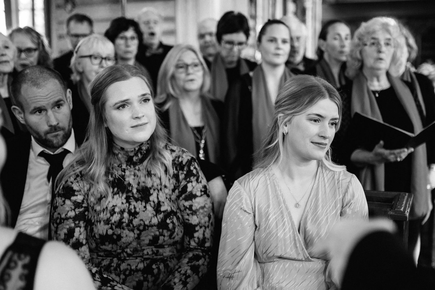 Wedding guests watch intently during an emotional ceremony moment.