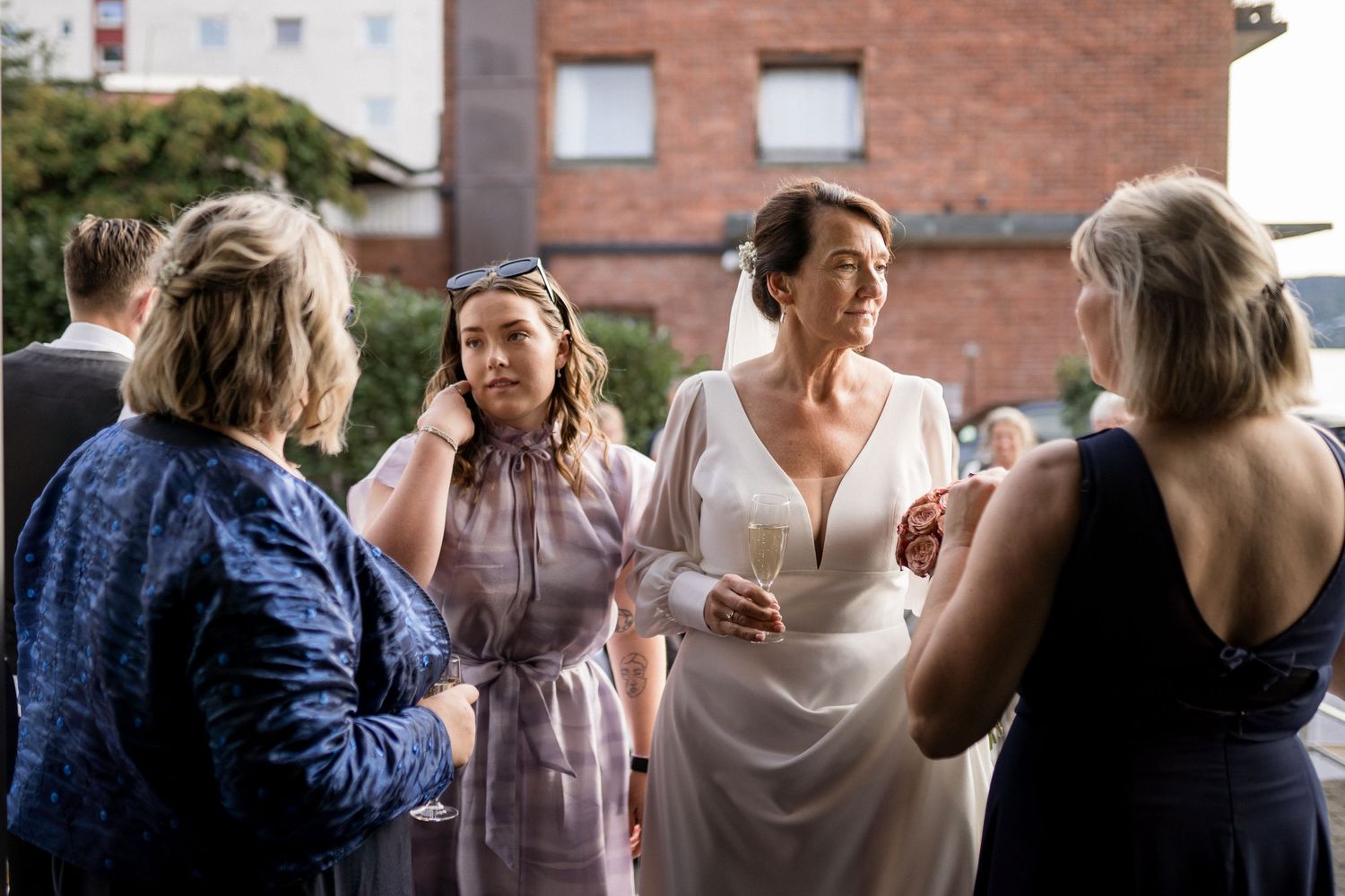 Guests socialize during an outdoor wedding reception.