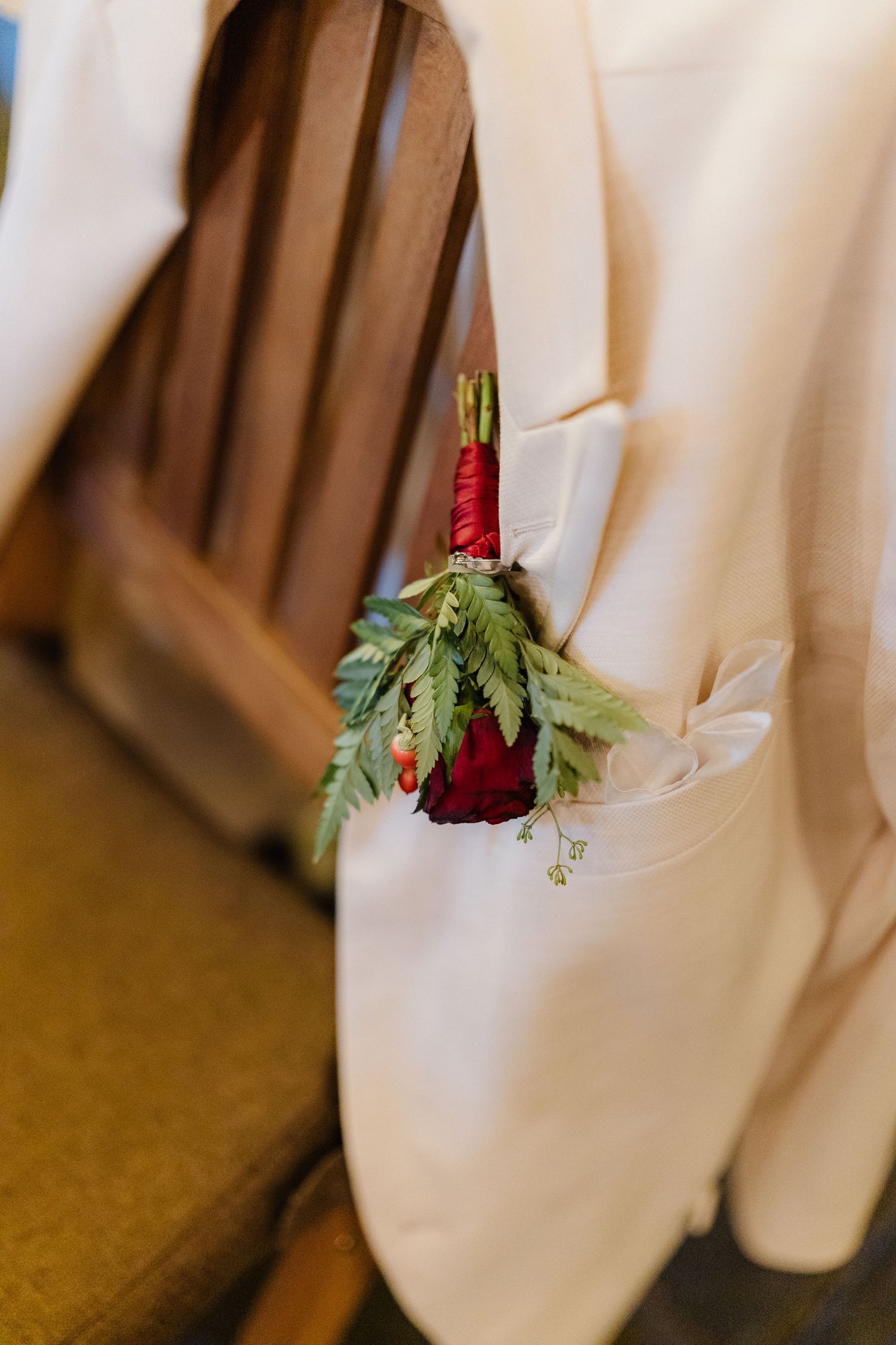 White napkins decorated with red flowers and greenery arranged for a formal event.
