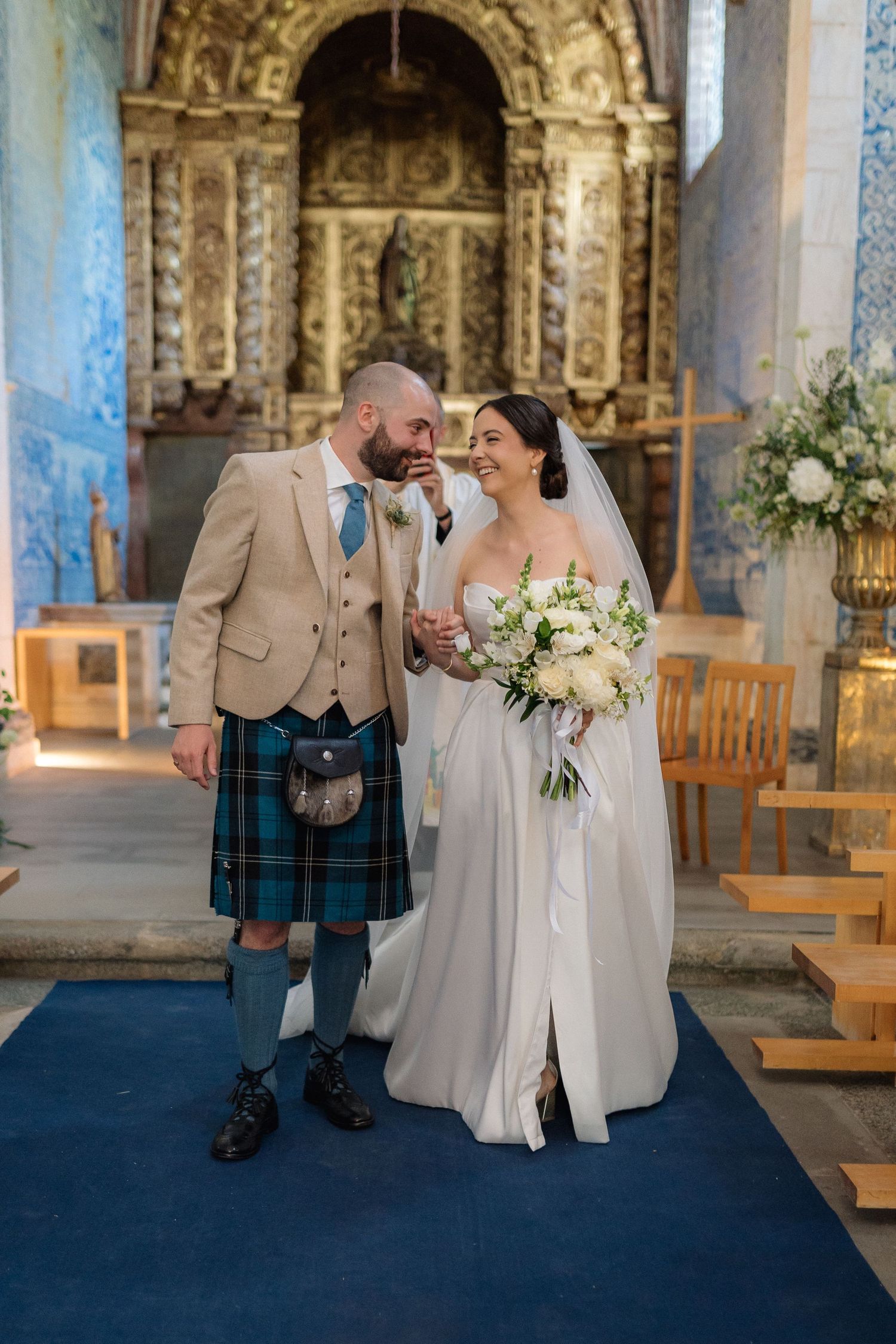 Wedding ceremony in historic church with blue and white decor and Scottish traditional elements.