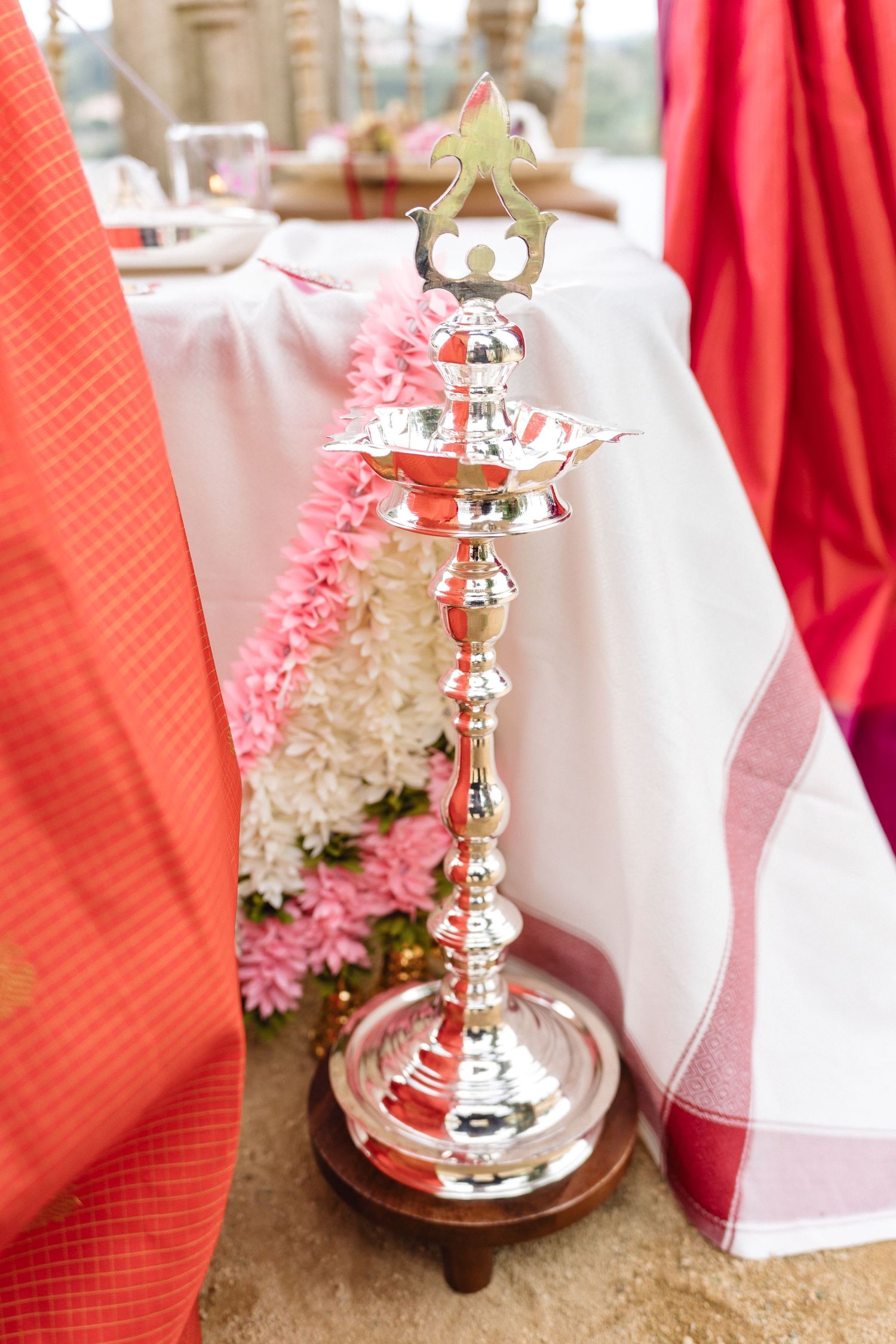 Elegant table settings with silver bell decorations and pink floral accents.