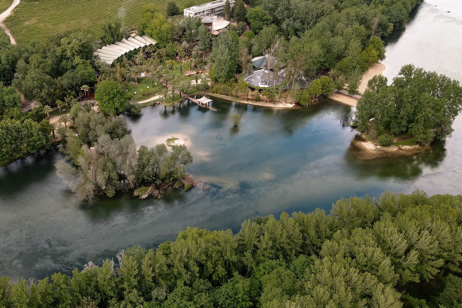 Aerial view of a waterfront property surrounded by lush green trees and waterways.