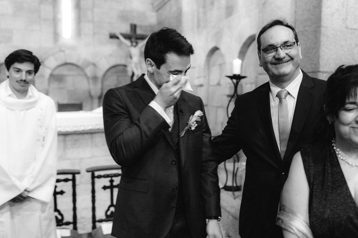 Guests at a formal event share laughter and conversation while wearing suits and formal attire.