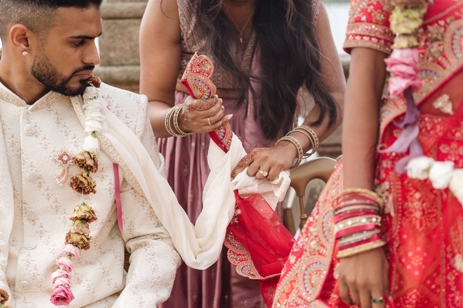 Wedding guests in colorful traditional Indian outfits gather for celebration.