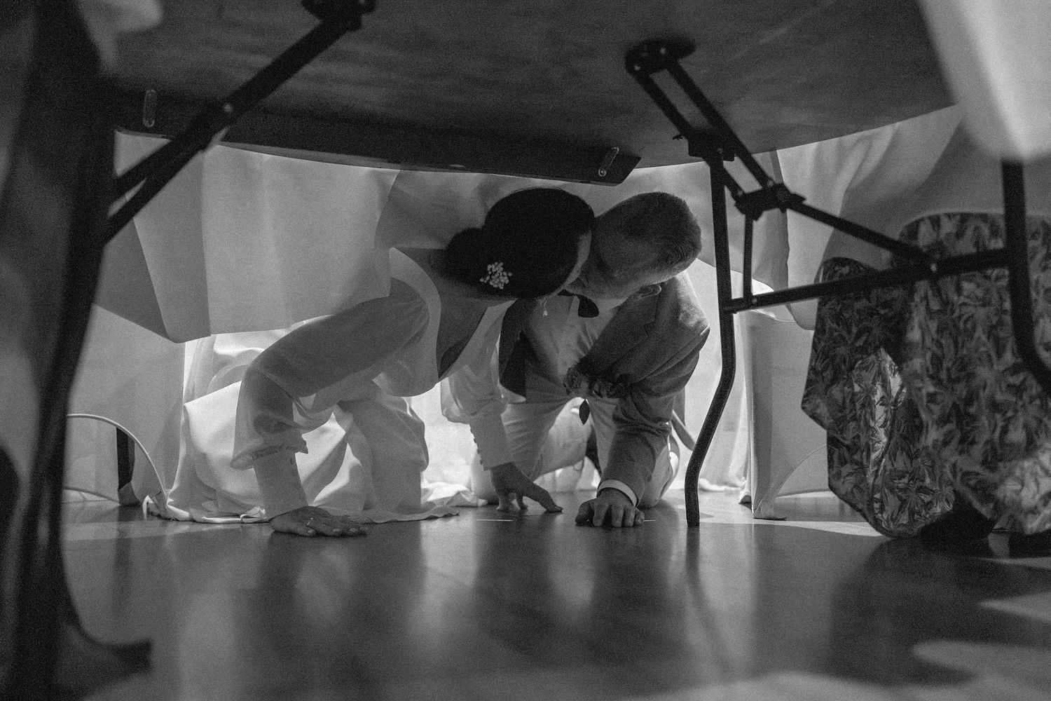 Black and white photo showing feet and shoes of people dancing at a wedding reception.