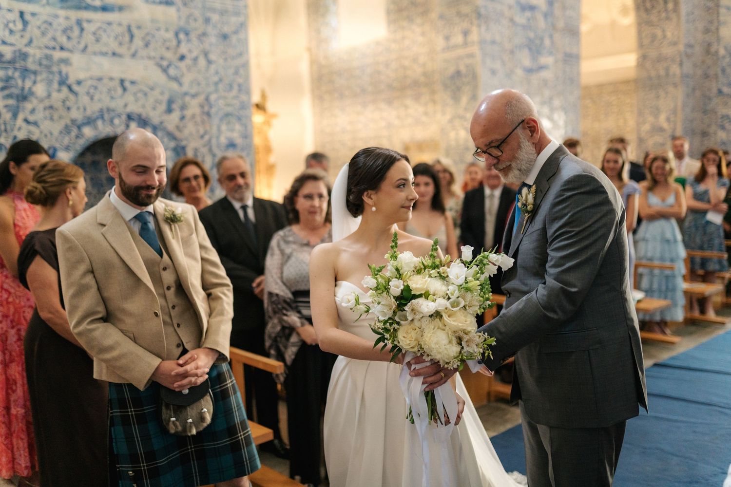 Wedding ceremony moments captured in a beautiful Portuguese chapel with traditional blue tile walls.