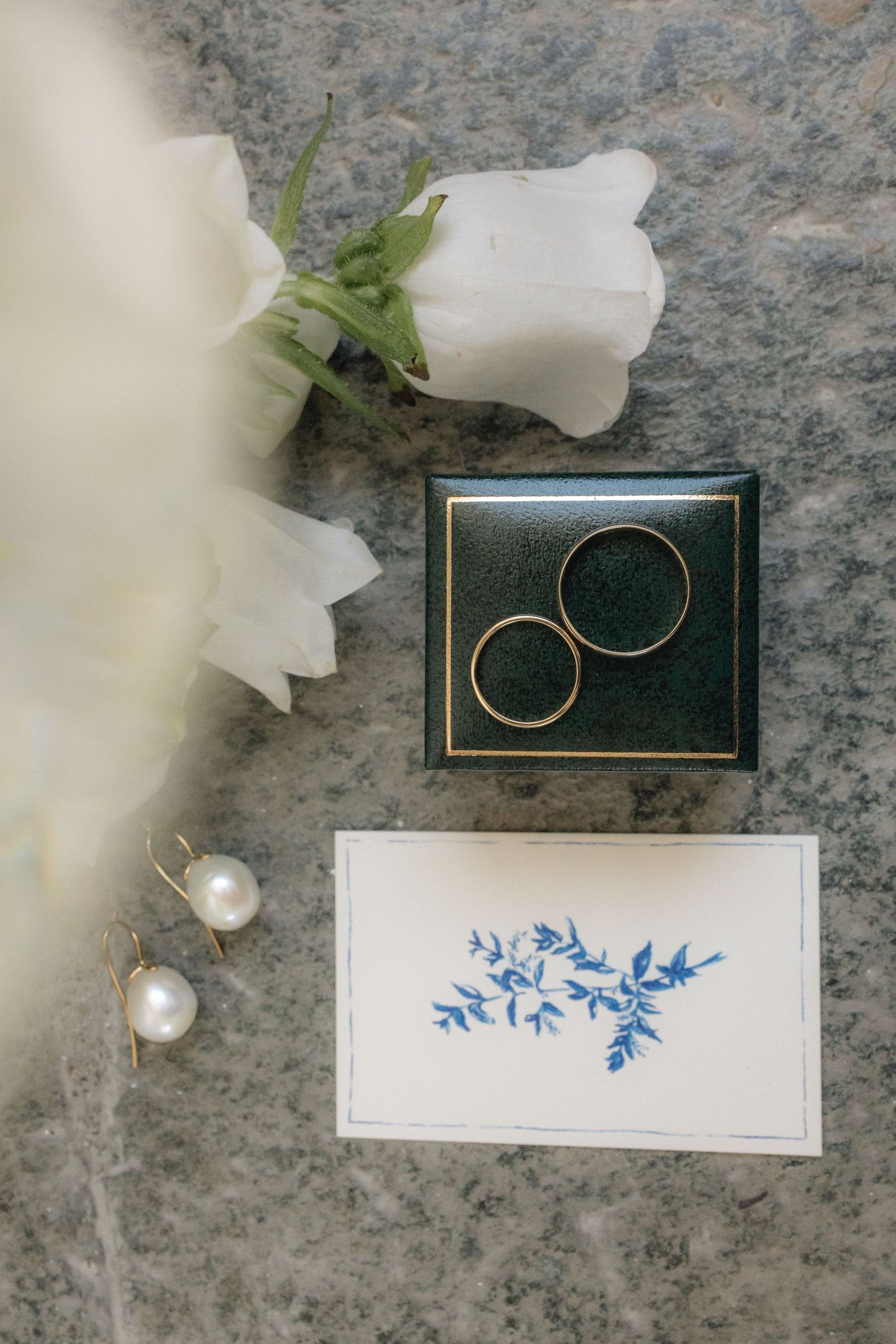 Wedding stationery details with elegant white flowers, pearl accents, and blue floral designs on cards.