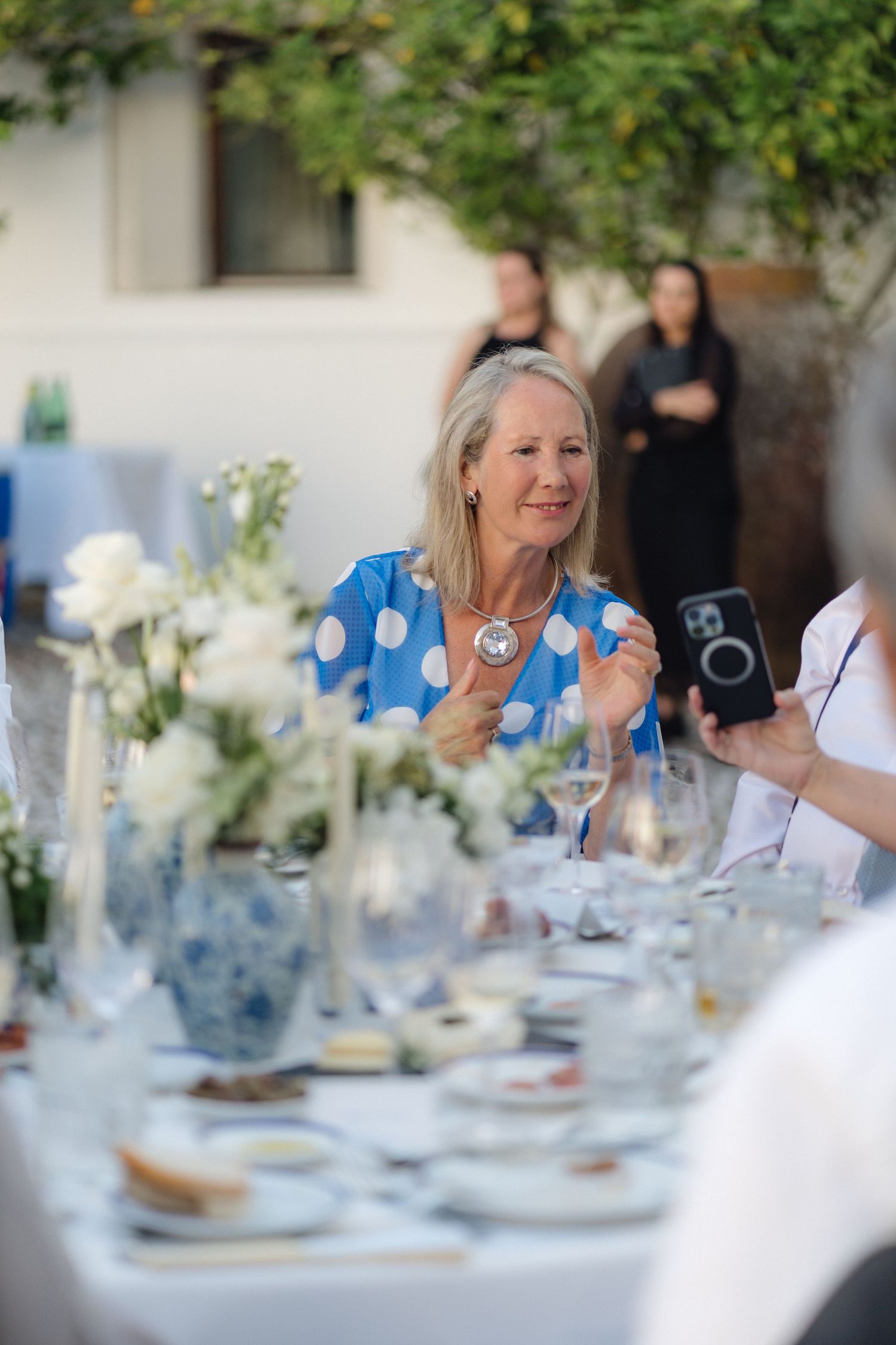 Elegant table settings with blue and white decor at an outdoor summer celebration.