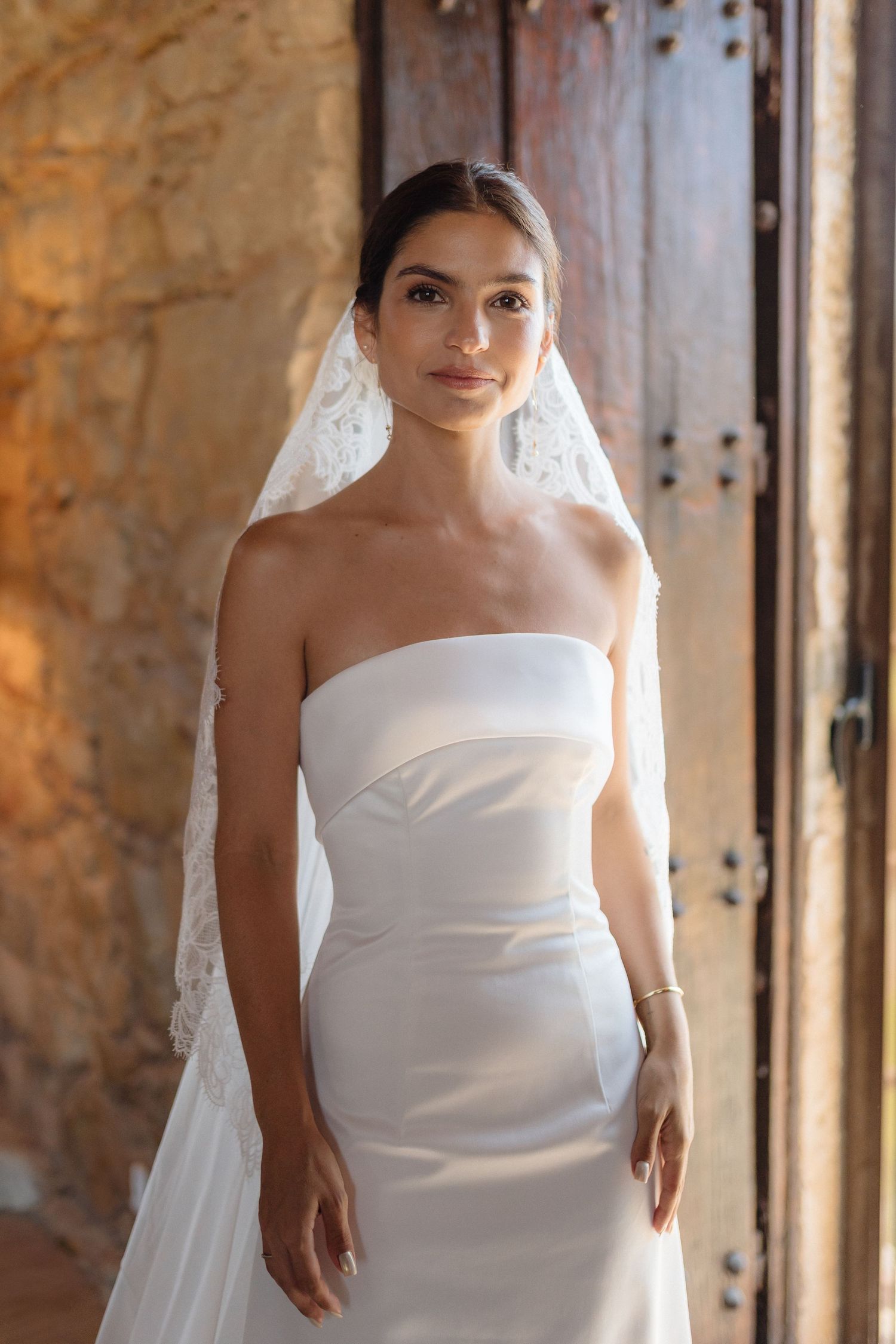 A classic strapless wedding dress captured in a historic stone building.