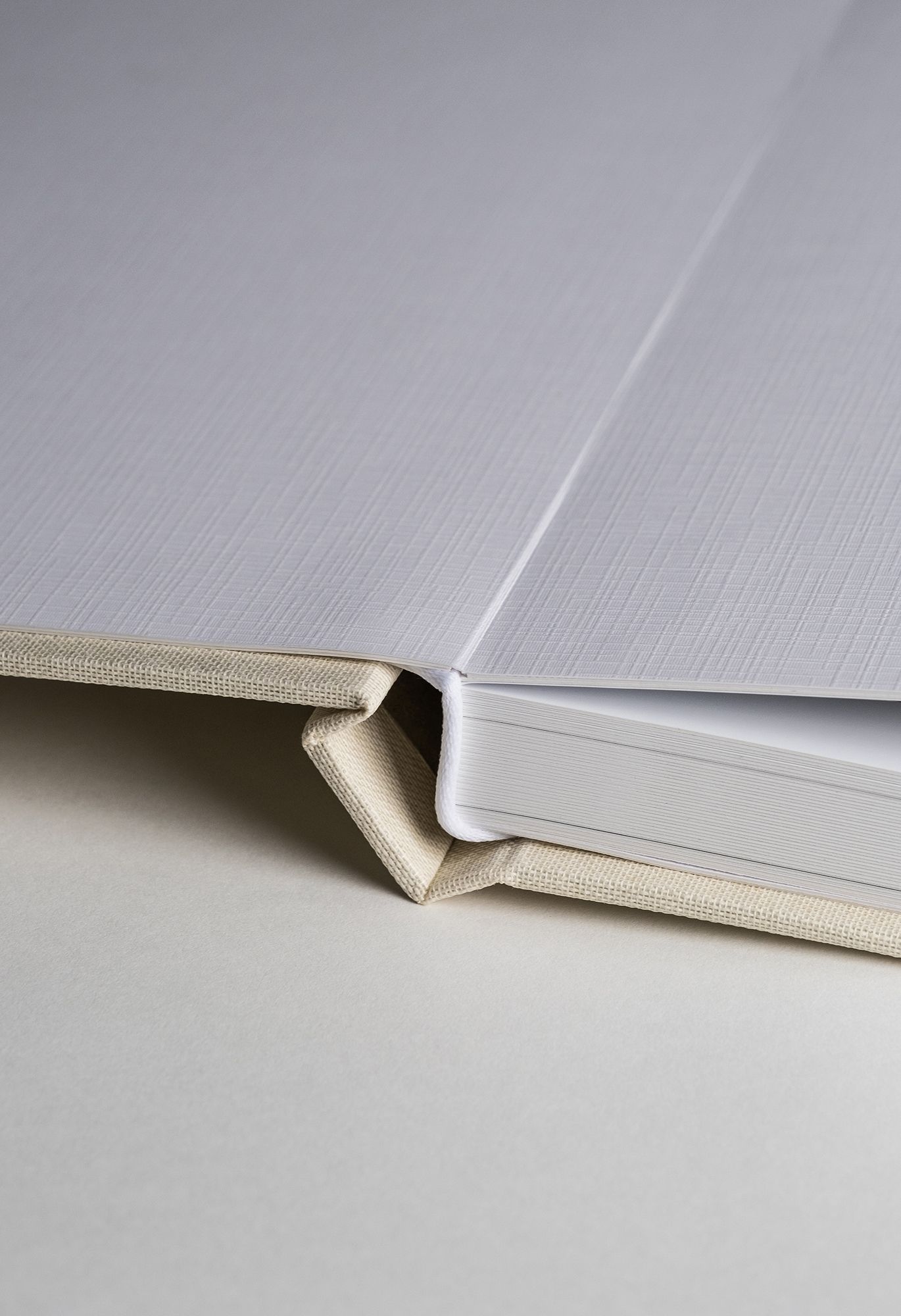 Close-up sequence of white hardcover book binding details showing spine and page attachment construction.