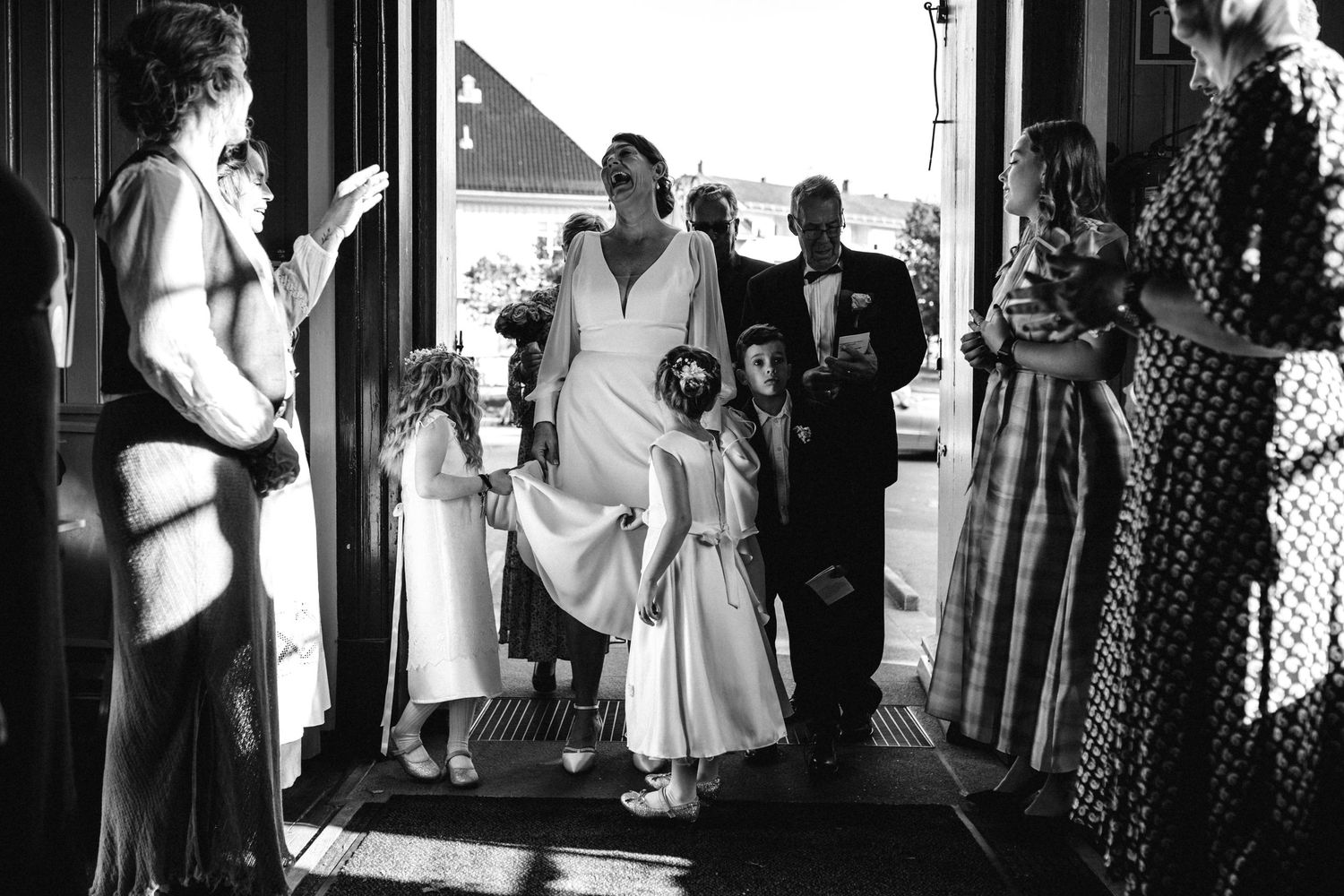 Black and white candid shots of people interacting in a hallway with strong contrast lighting.