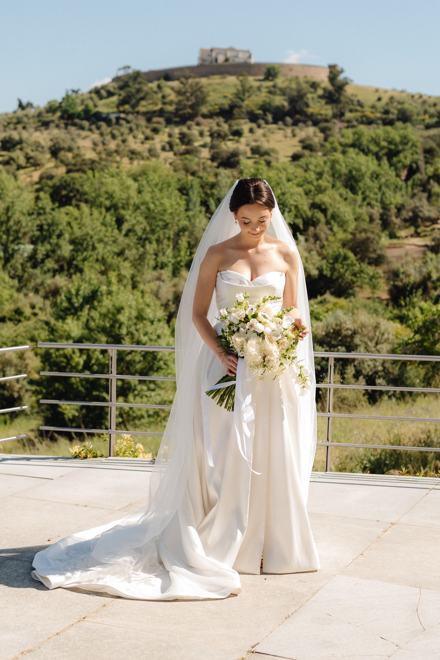 Bridal portrait on sunny terrace with scenic mountain views.