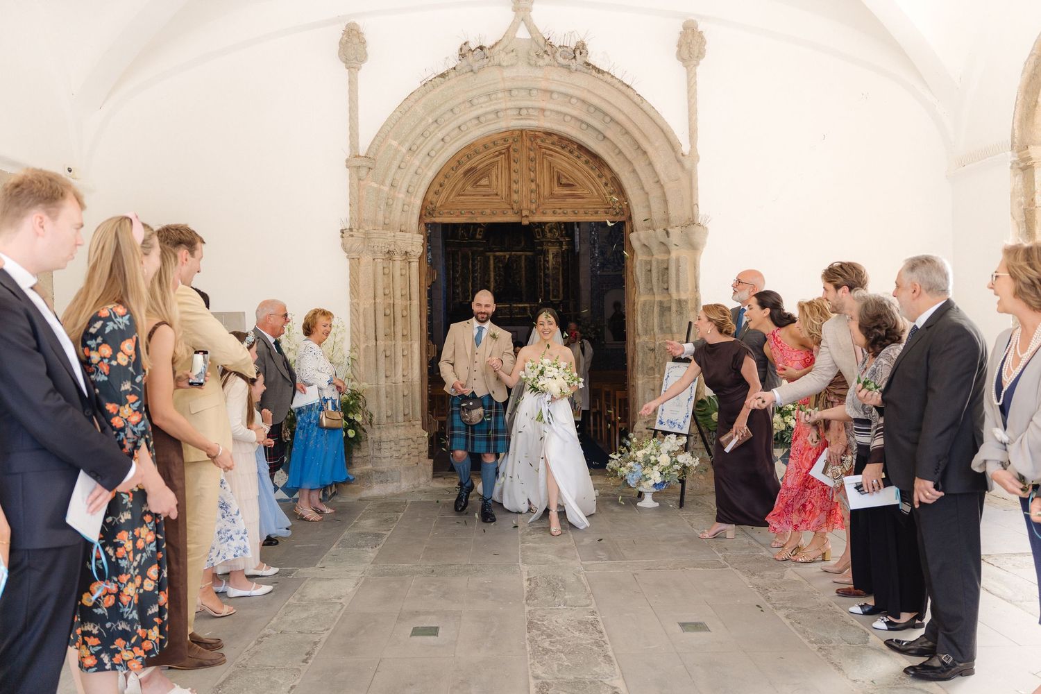 Wedding guests line church corridor during ceremony exit.