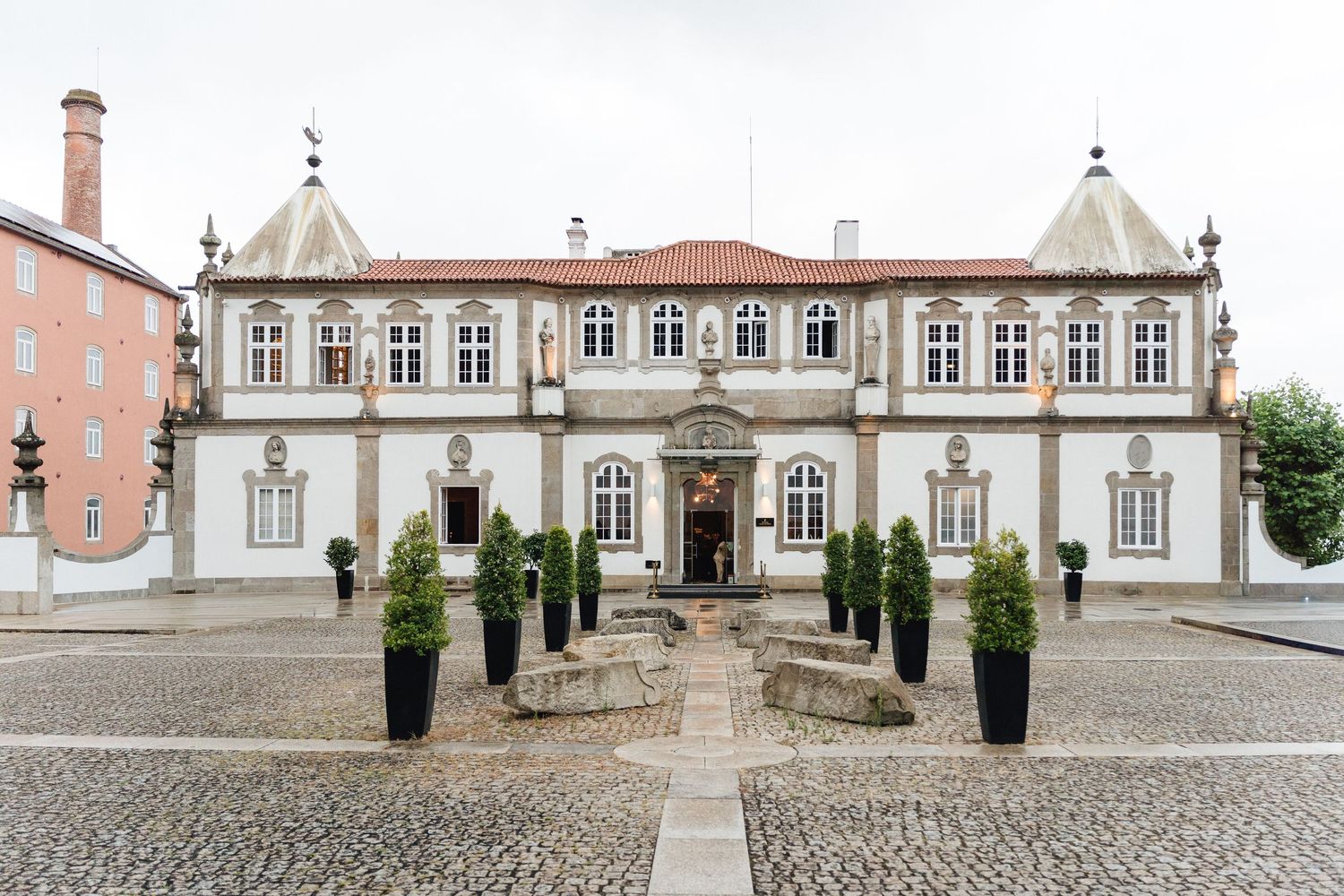 Panoramic view of a historic Portuguese palace with cobblestone courtyard and ornate classical architecture details.