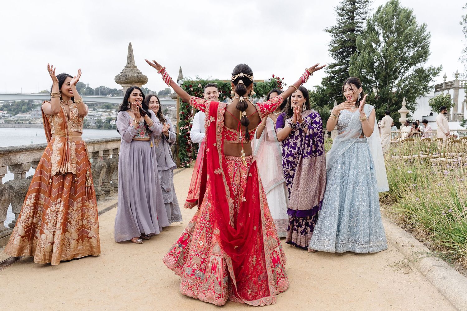 Wedding guests in colorful traditional Indian attire celebrating outdoors.