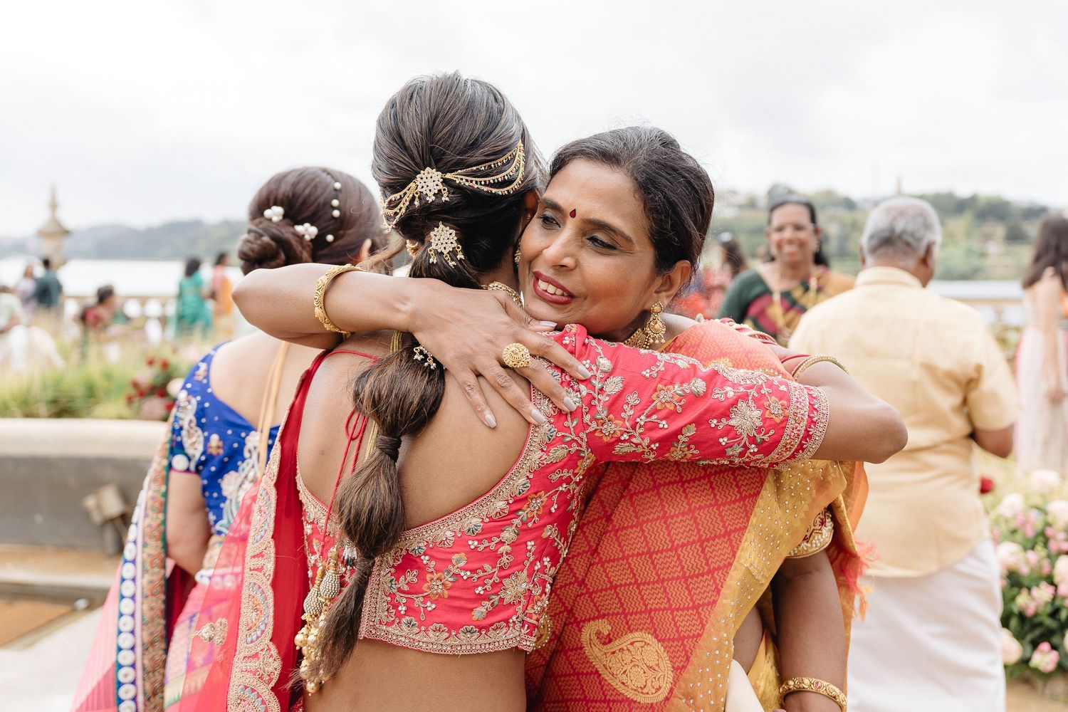 Emotional wedding celebration moments with guests embracing outdoors.