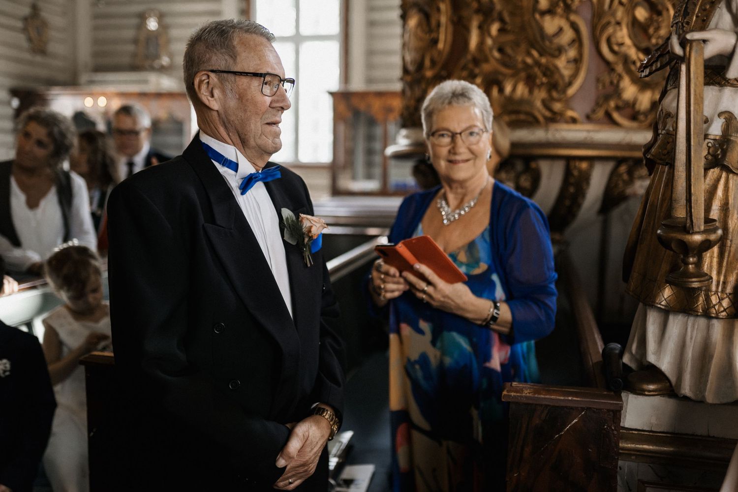 A couple shares a tender moment during a wedding celebration in an elegant church setting.