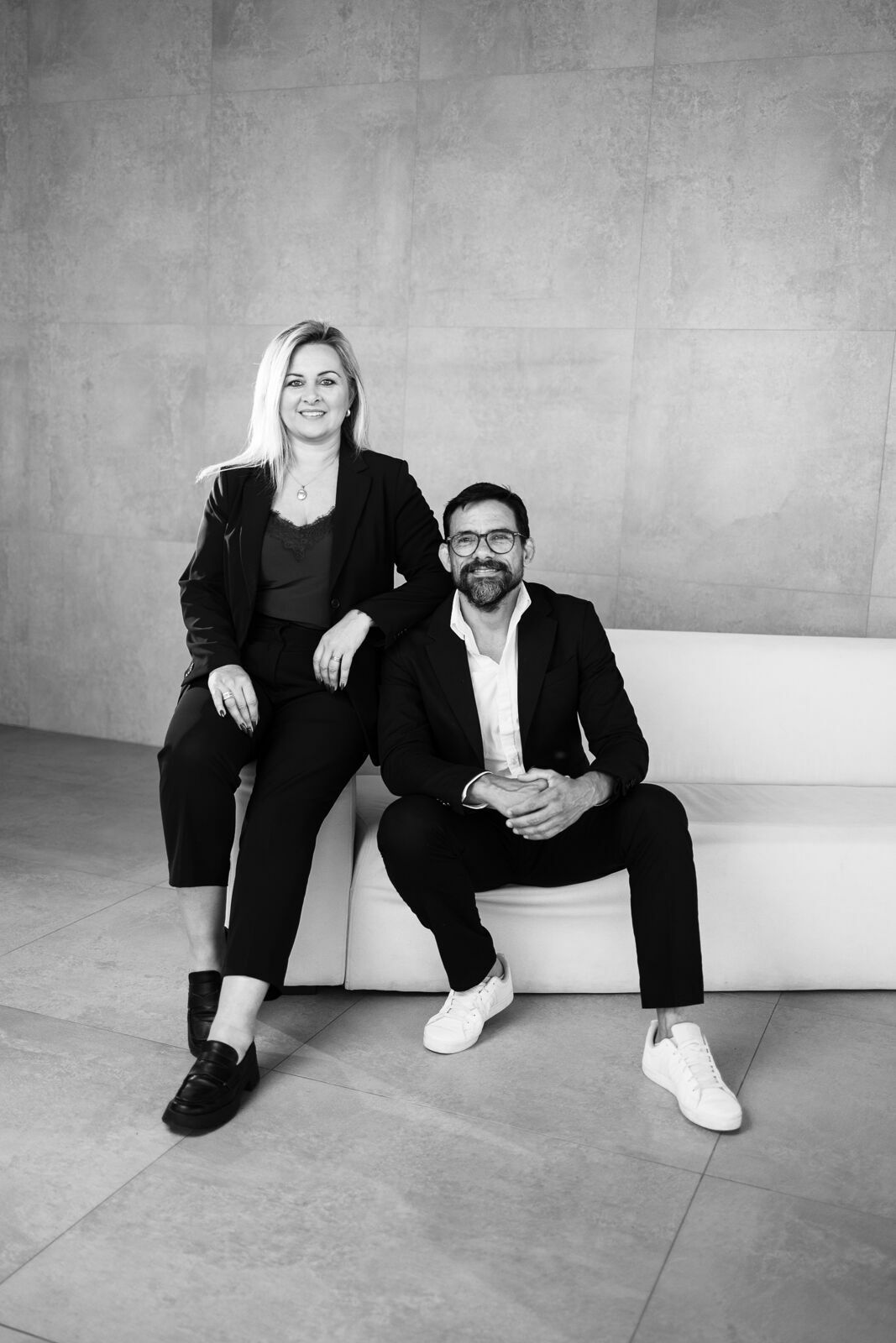 Casual portrait series of people sitting on a minimalist concrete bench in black and white.