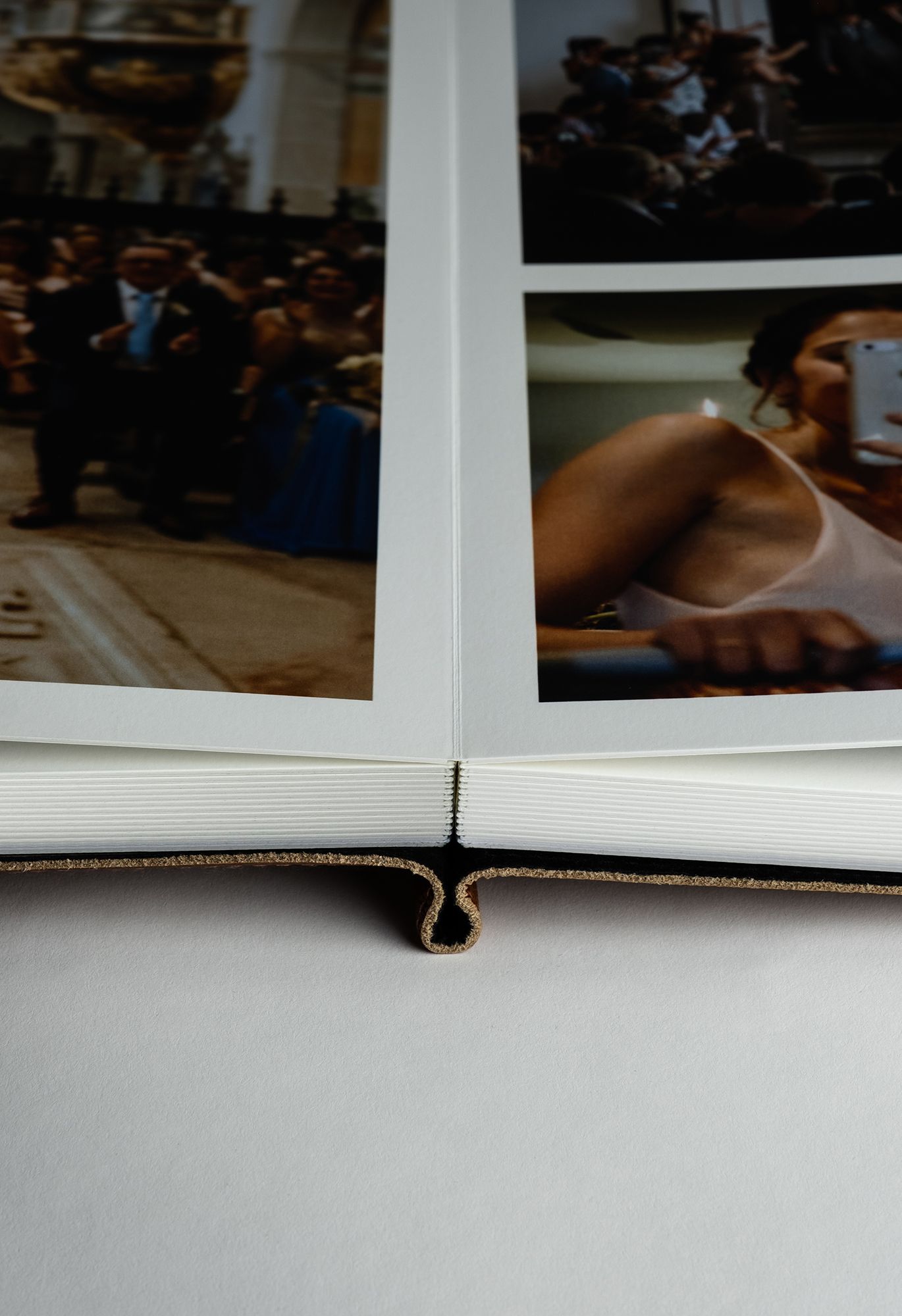 A close-up view of an open photo album showing partial photographs arranged on white pages.