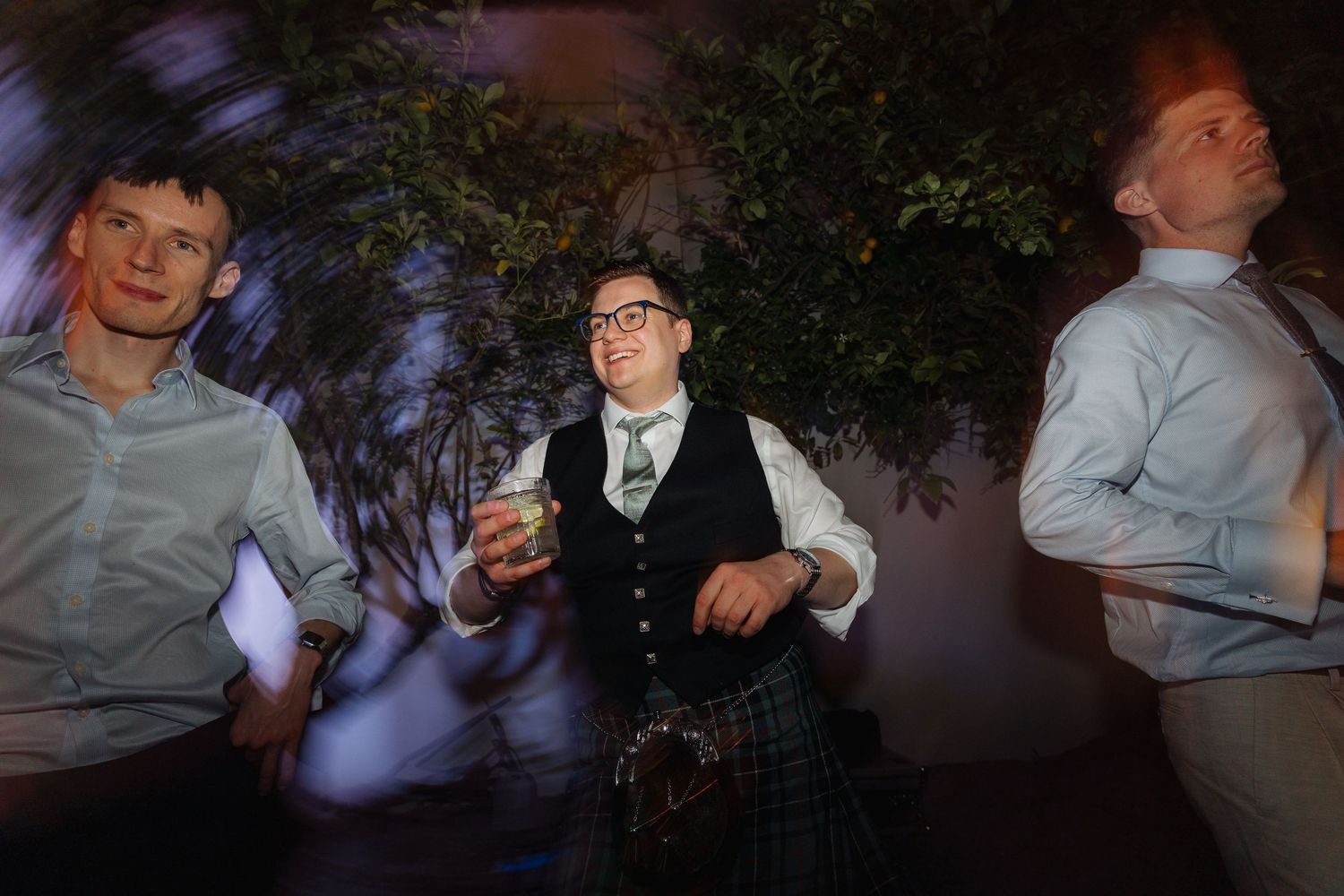 Nighttime celebration with guests dancing under moody lighting and decorative elements.