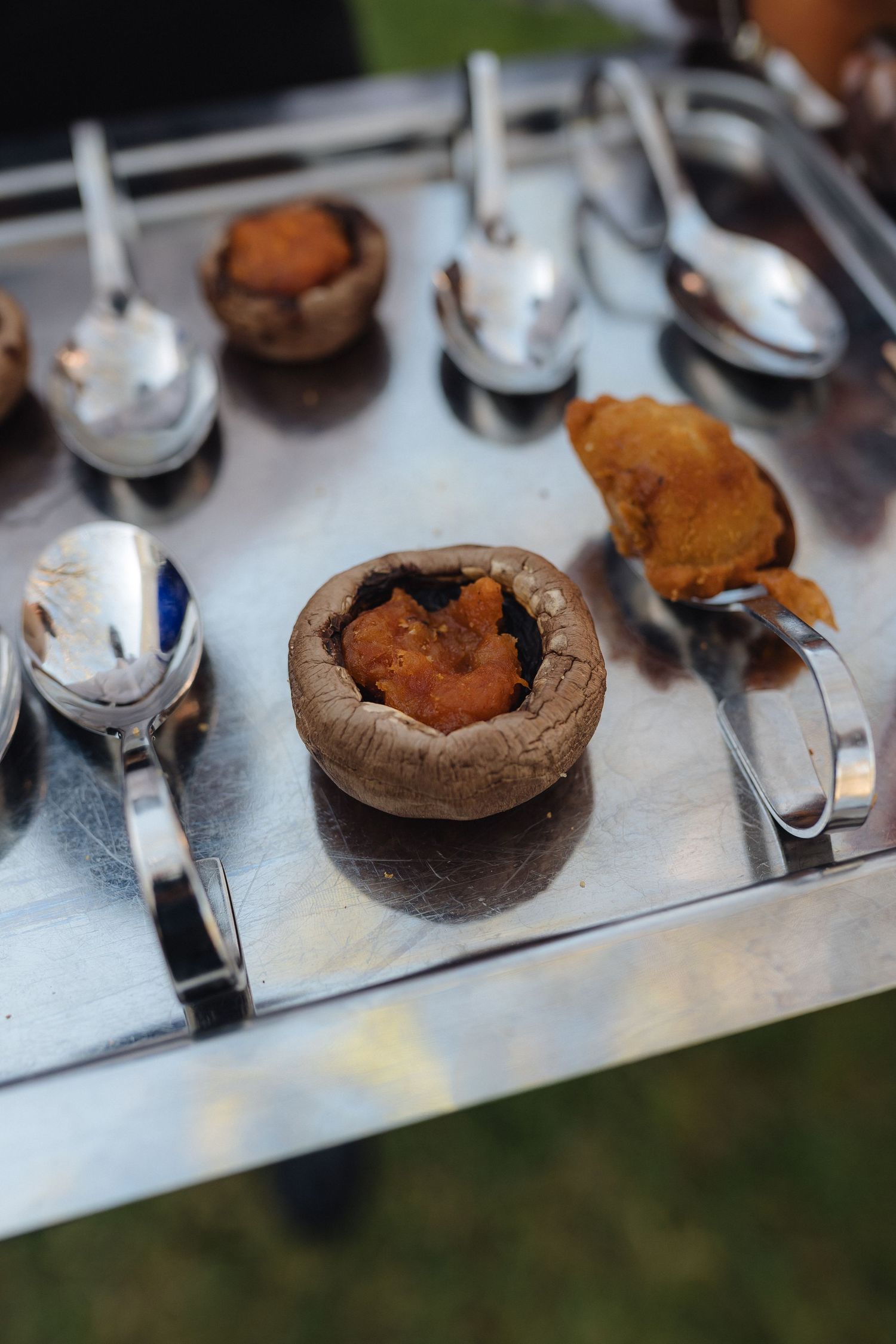 Close-up shot of chocolate desserts being plated on a metallic surface.