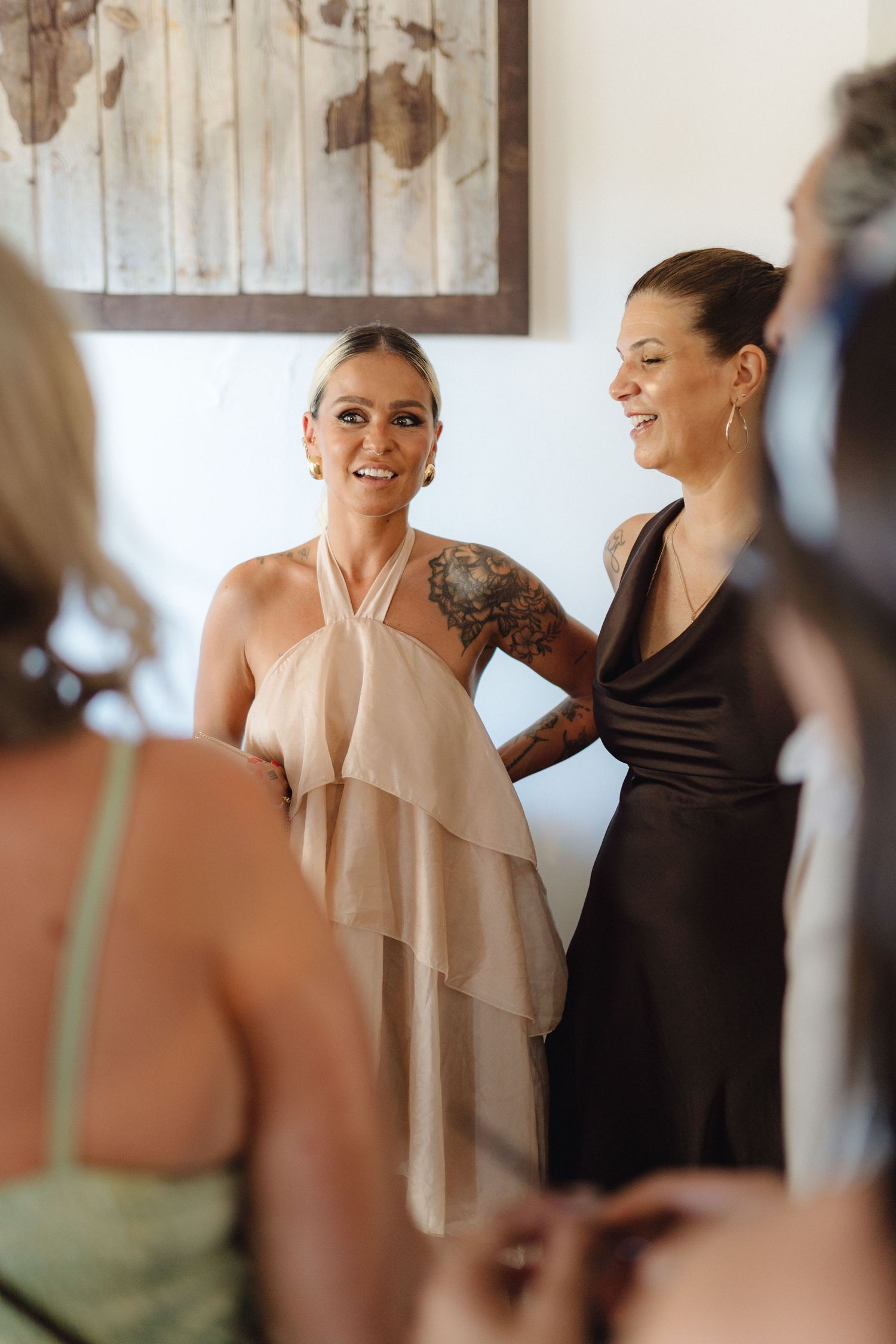People in formal attire sharing emotional moments during what appears to be a wedding preparation.