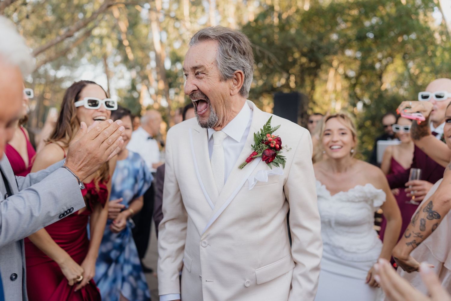 Wedding guests dancing and celebrating at an outdoor reception.