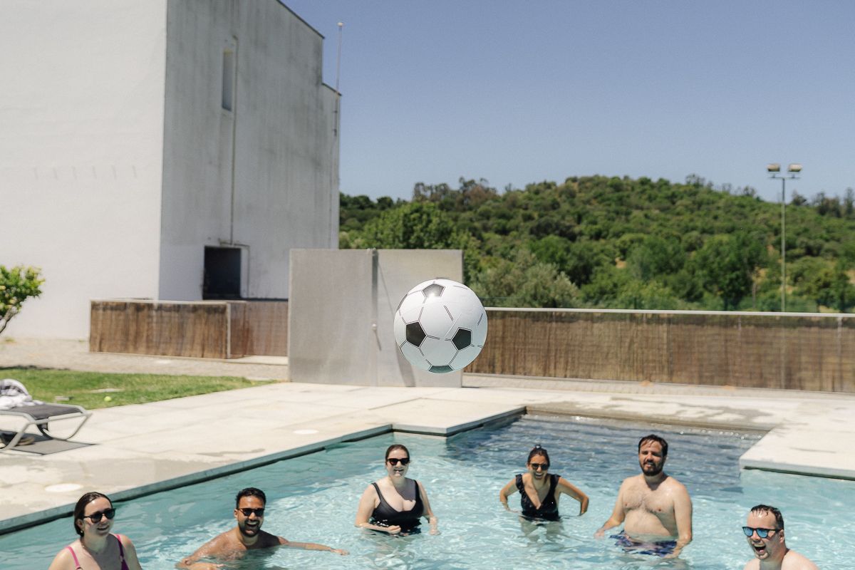 Aerial view of a modern swimming pool surrounded by concrete deck and landscaping.