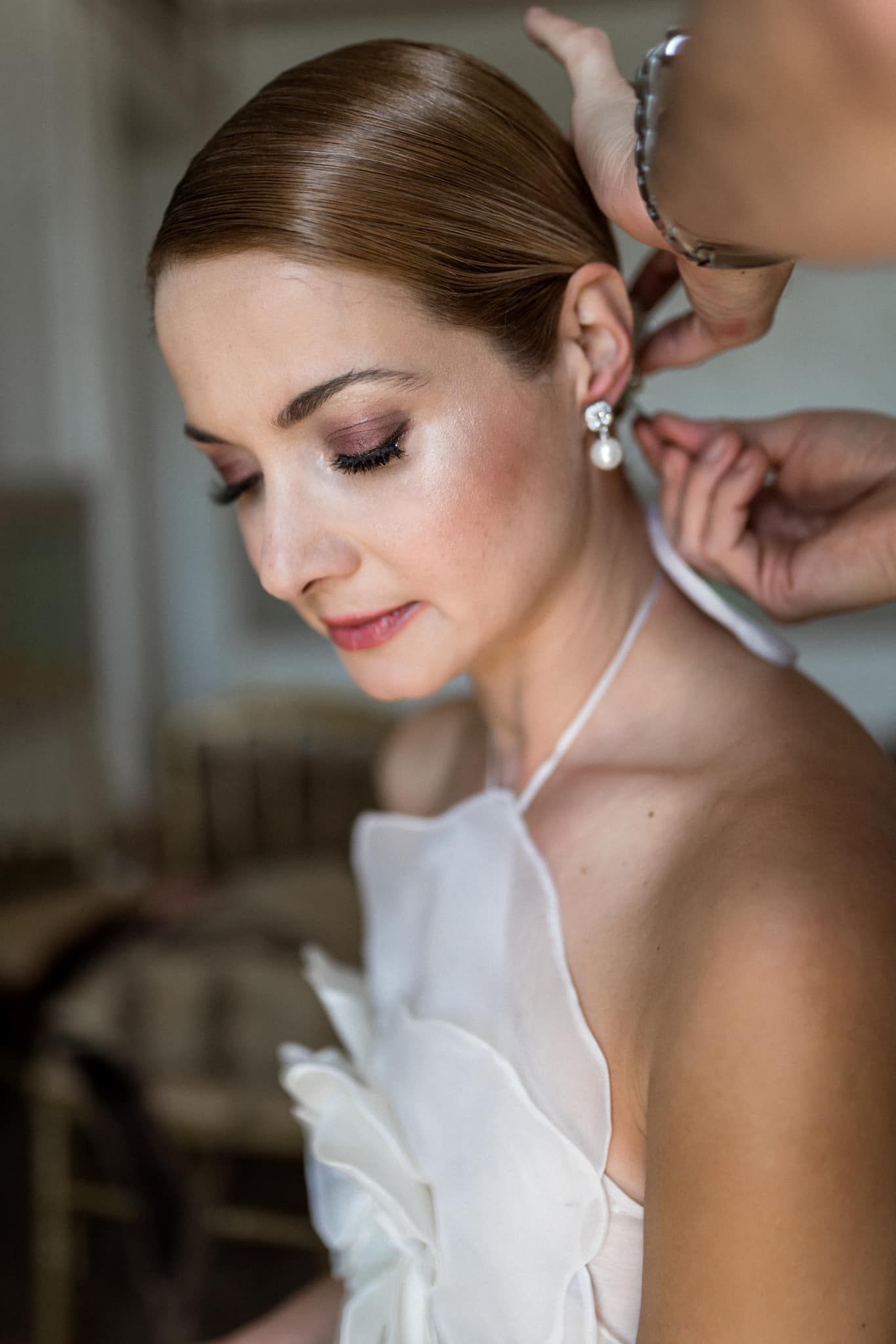 Close-up details of wedding day preparations with delicate jewelry and makeup.