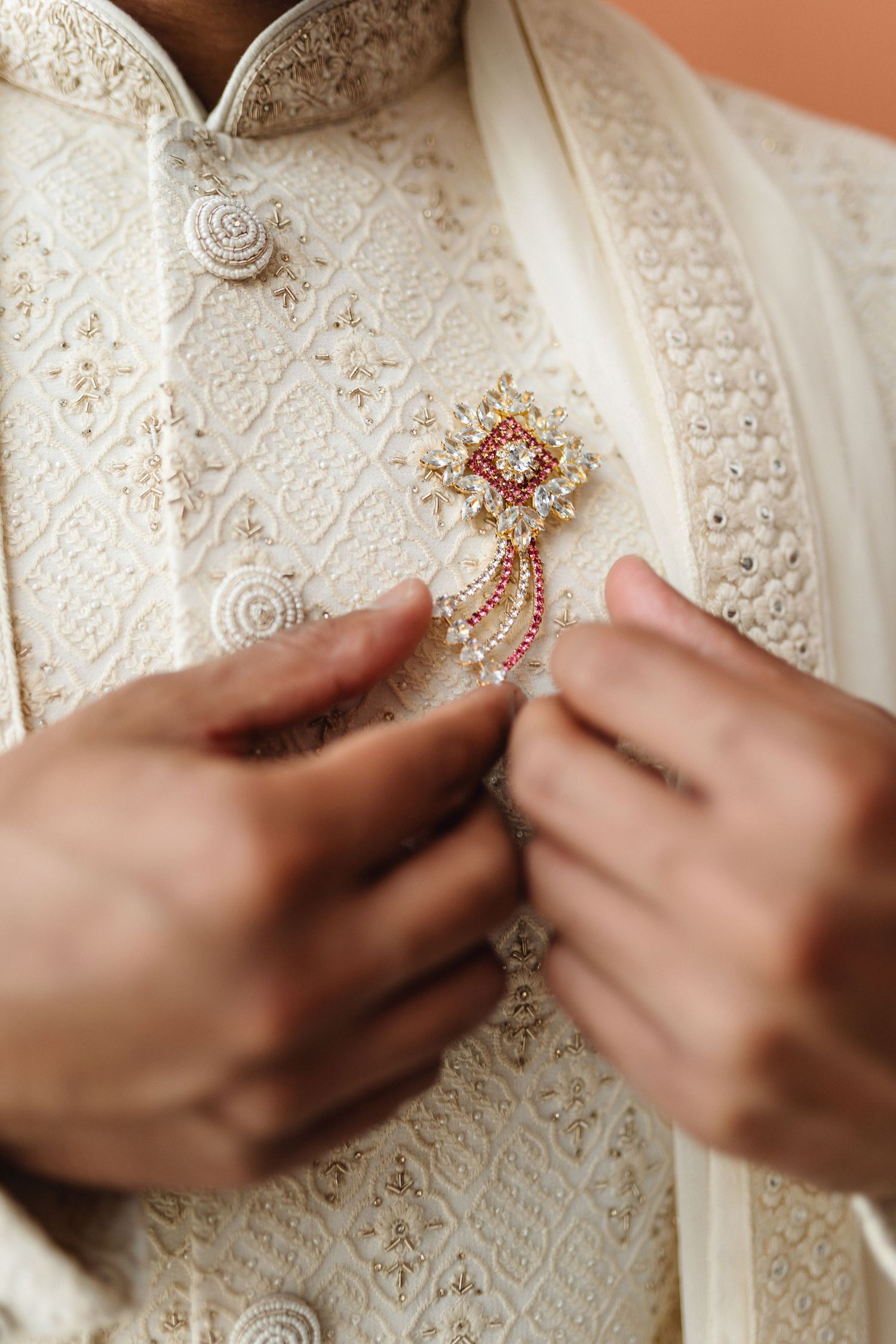 Close-up details of intricate beadwork and embellishments on an ornate white wedding dress.