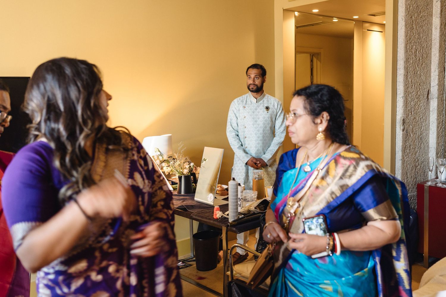 Wedding guests gathered in an indoor venue hallway during celebration.