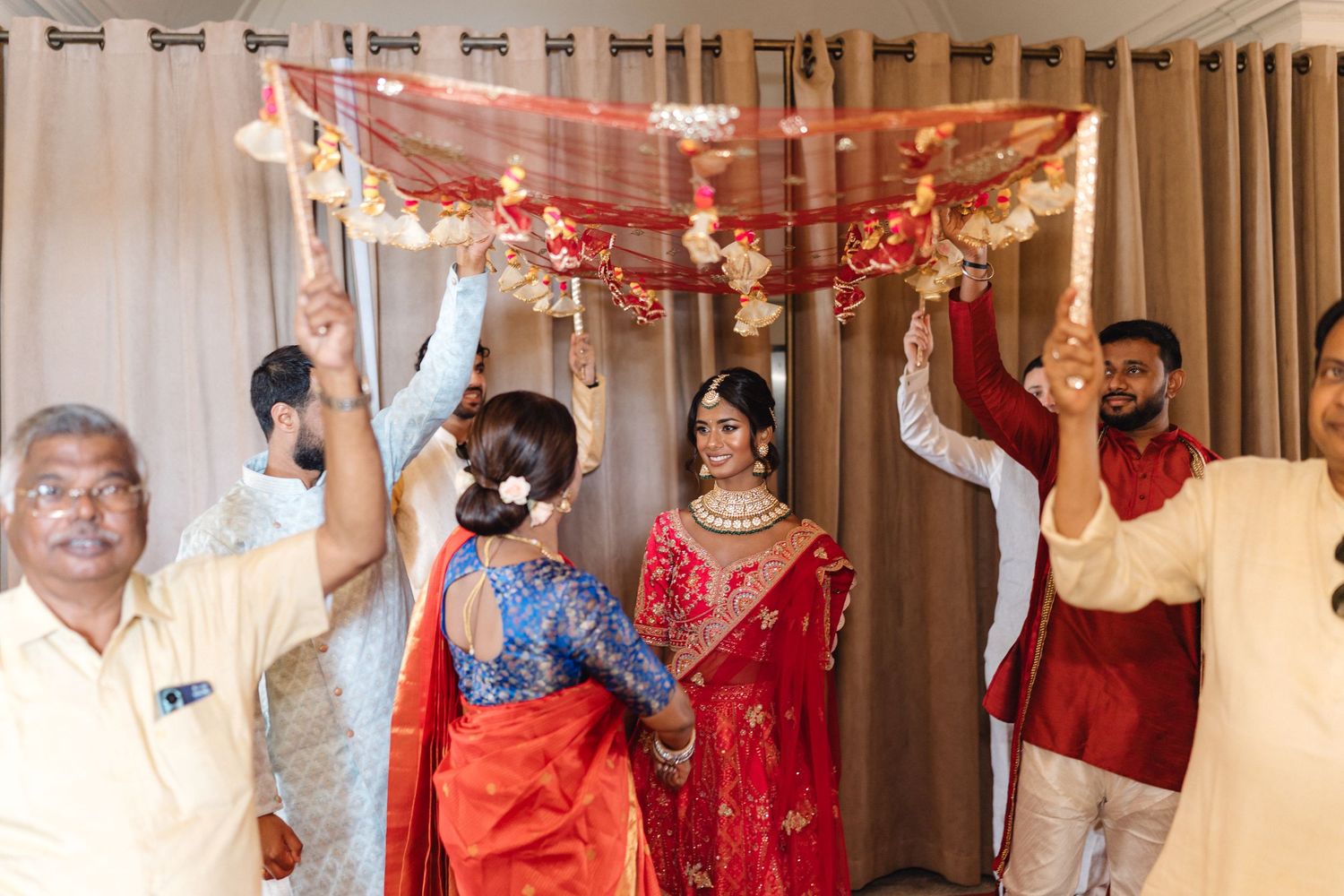 Wedding venue decorated with pink floral arrangements and hanging lights for celebration.