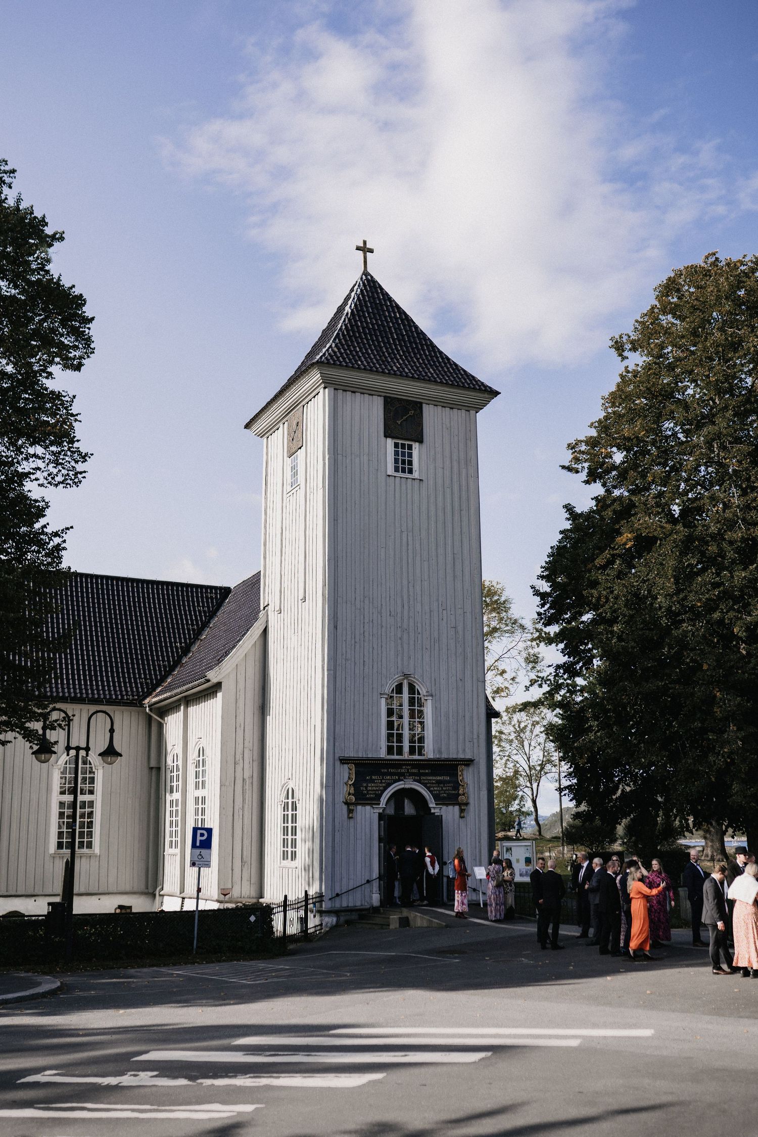 White wooden church exterior with steeple against blue sky shown from multiple angles.
