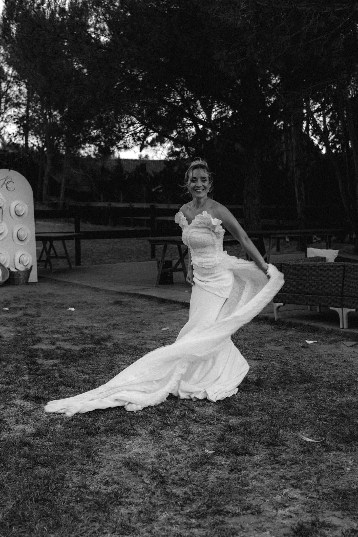 Series of black and white photos capture bride dancing joyfully in flowing dress outdoors.