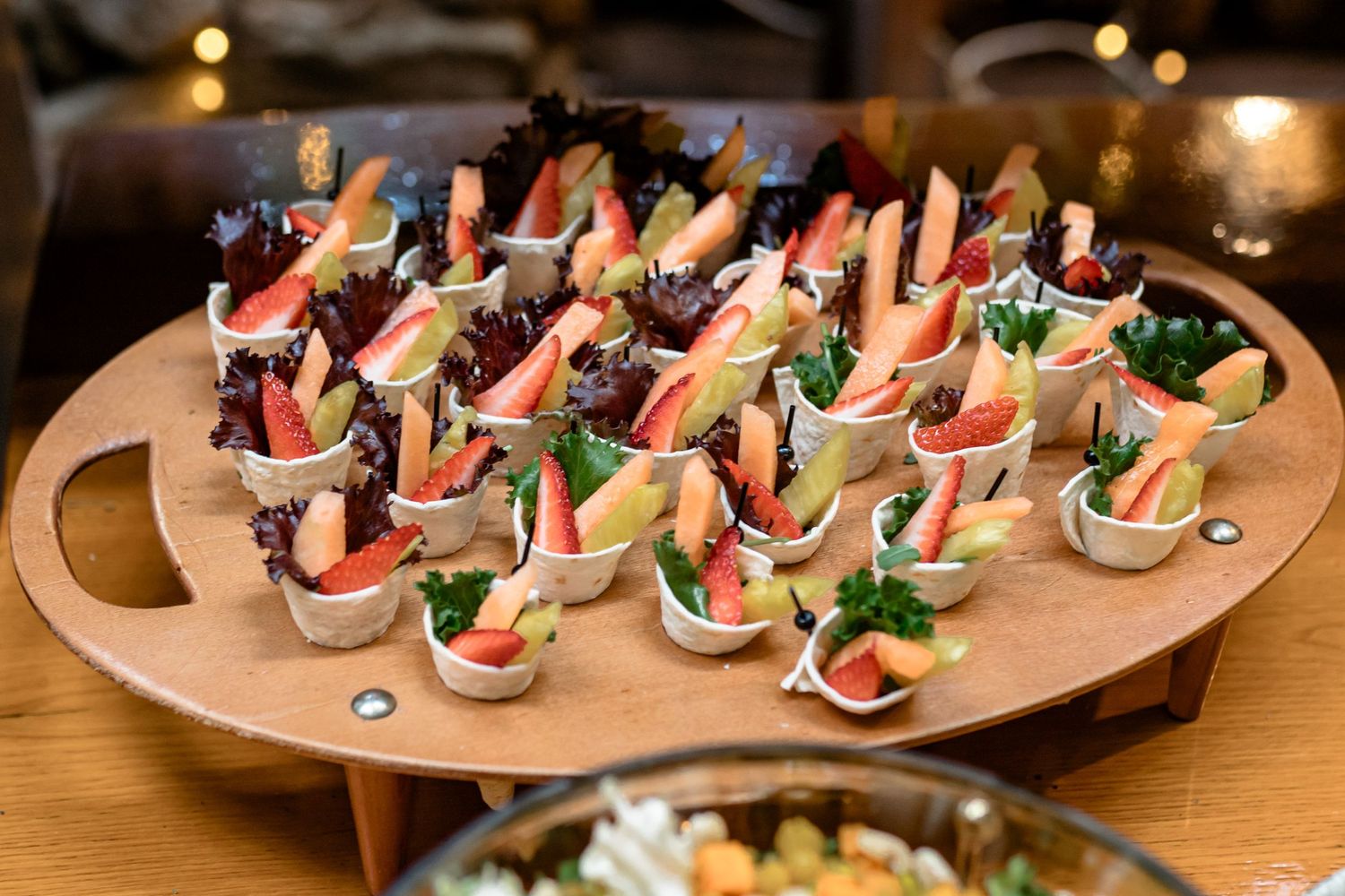 Elegant appetizers arranged on wooden serving boards at a catered event.