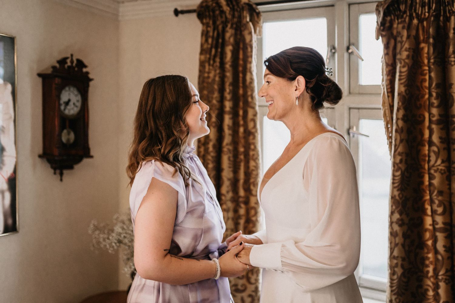 Getting ready scene in room with floral curtains as morning light streams through windows.