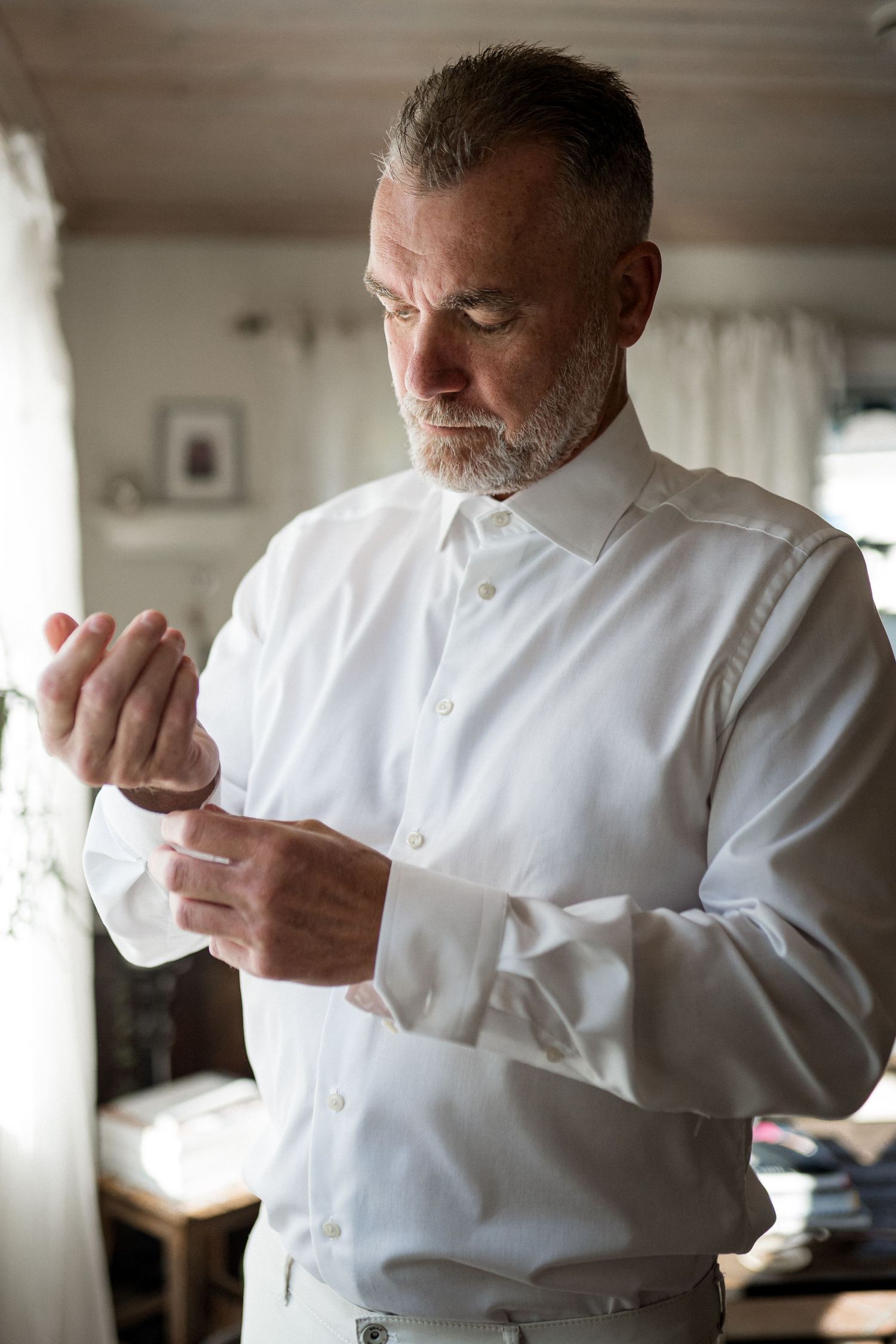 A person in a white shirt coughing or sneezing into their elbow in a sequence of photos.