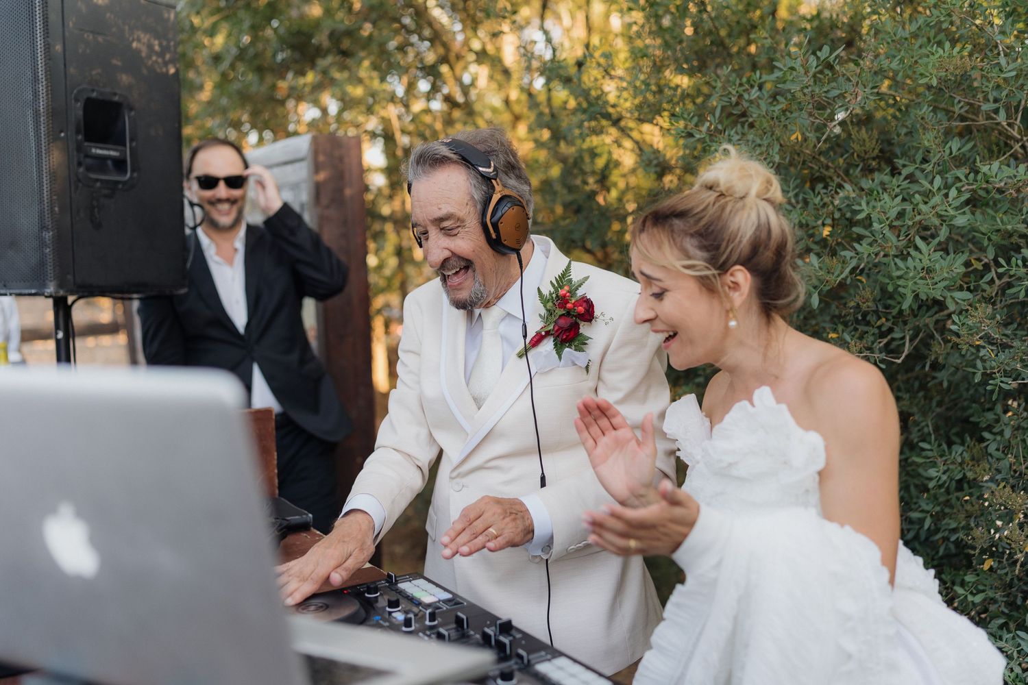 DJ entertaining guests at outdoor wedding reception with professional equipment setup.