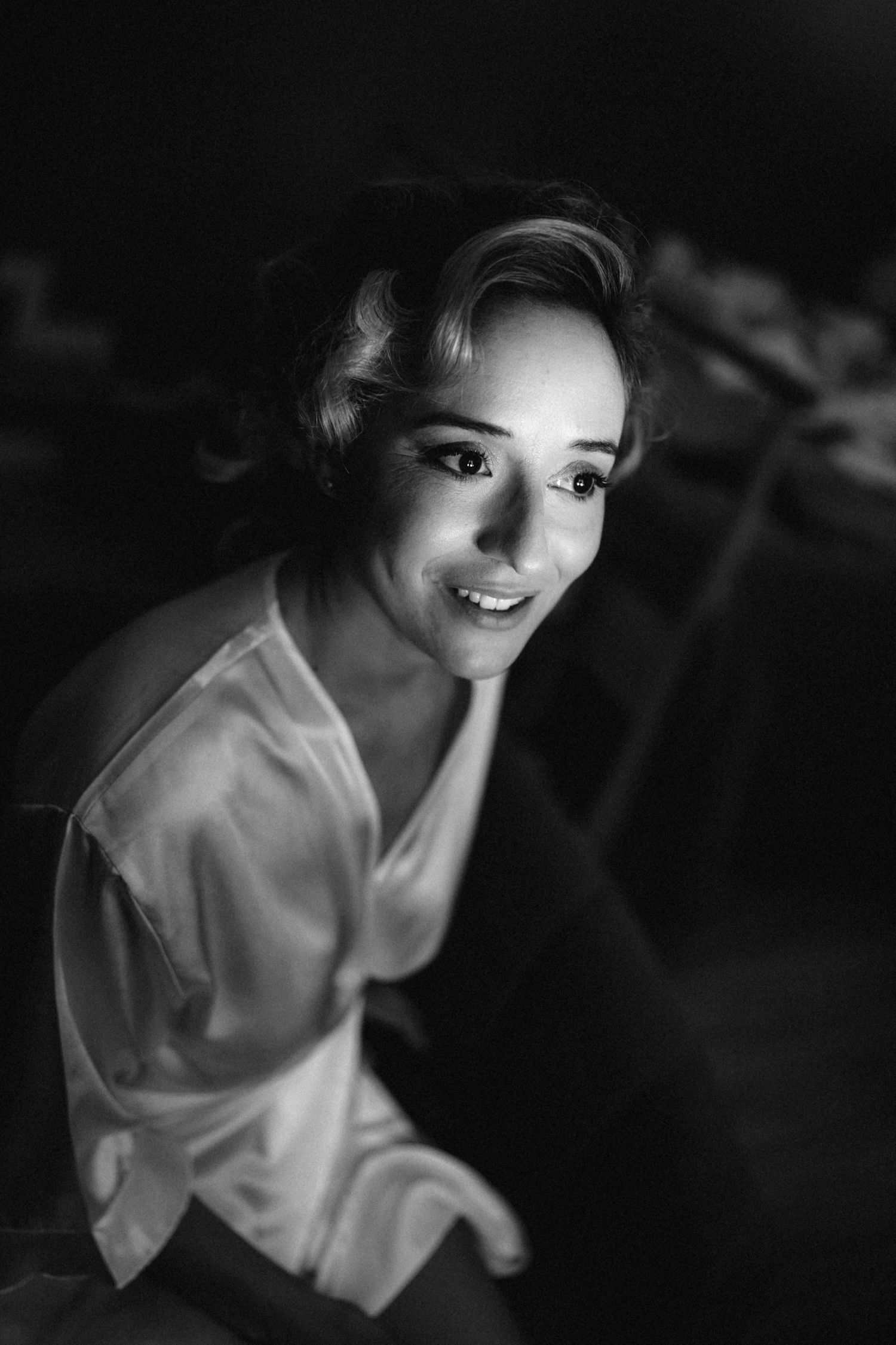 Close-up black and white portrait with dramatic side lighting.