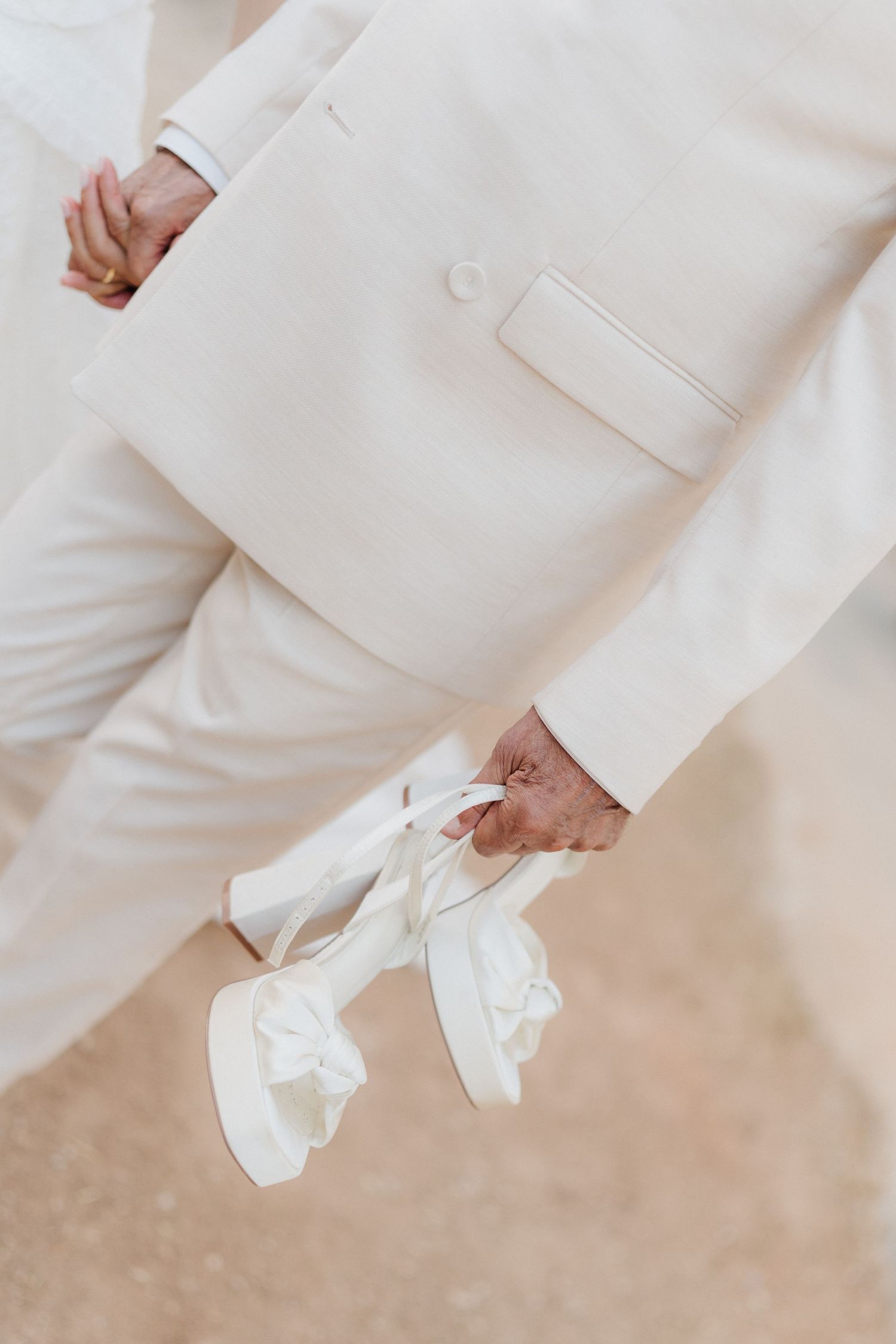 Close-up detail shot of white wedding attire against a natural background.