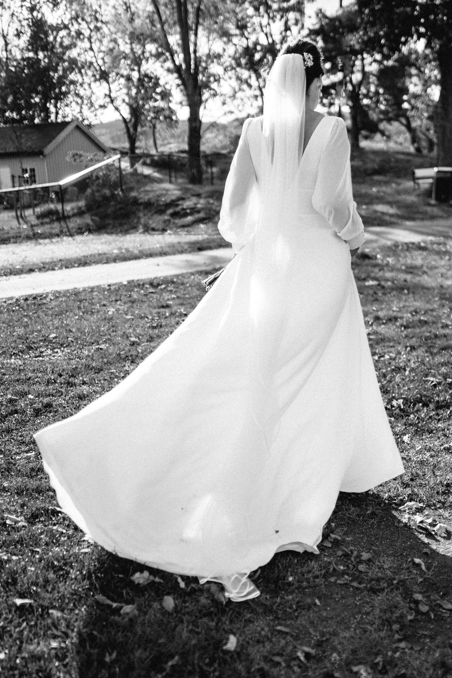 Flowing white dress twirling in black and white photo outdoors.