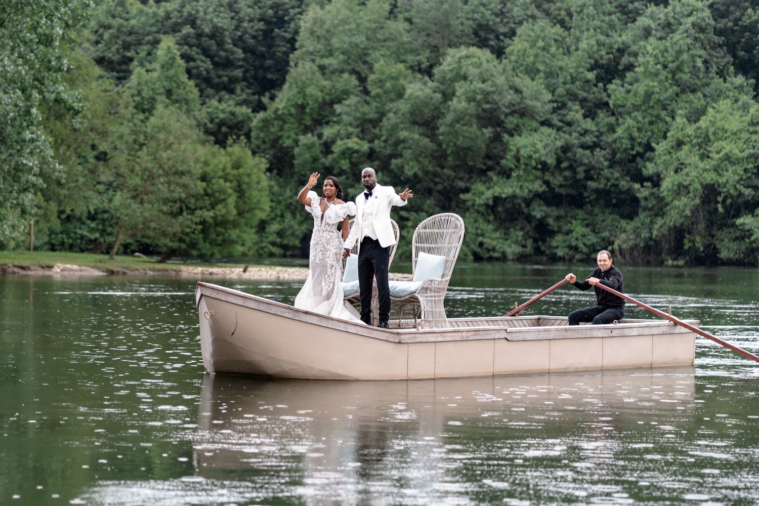 A couple celebrates their wedding on a small boat on a serene lake.