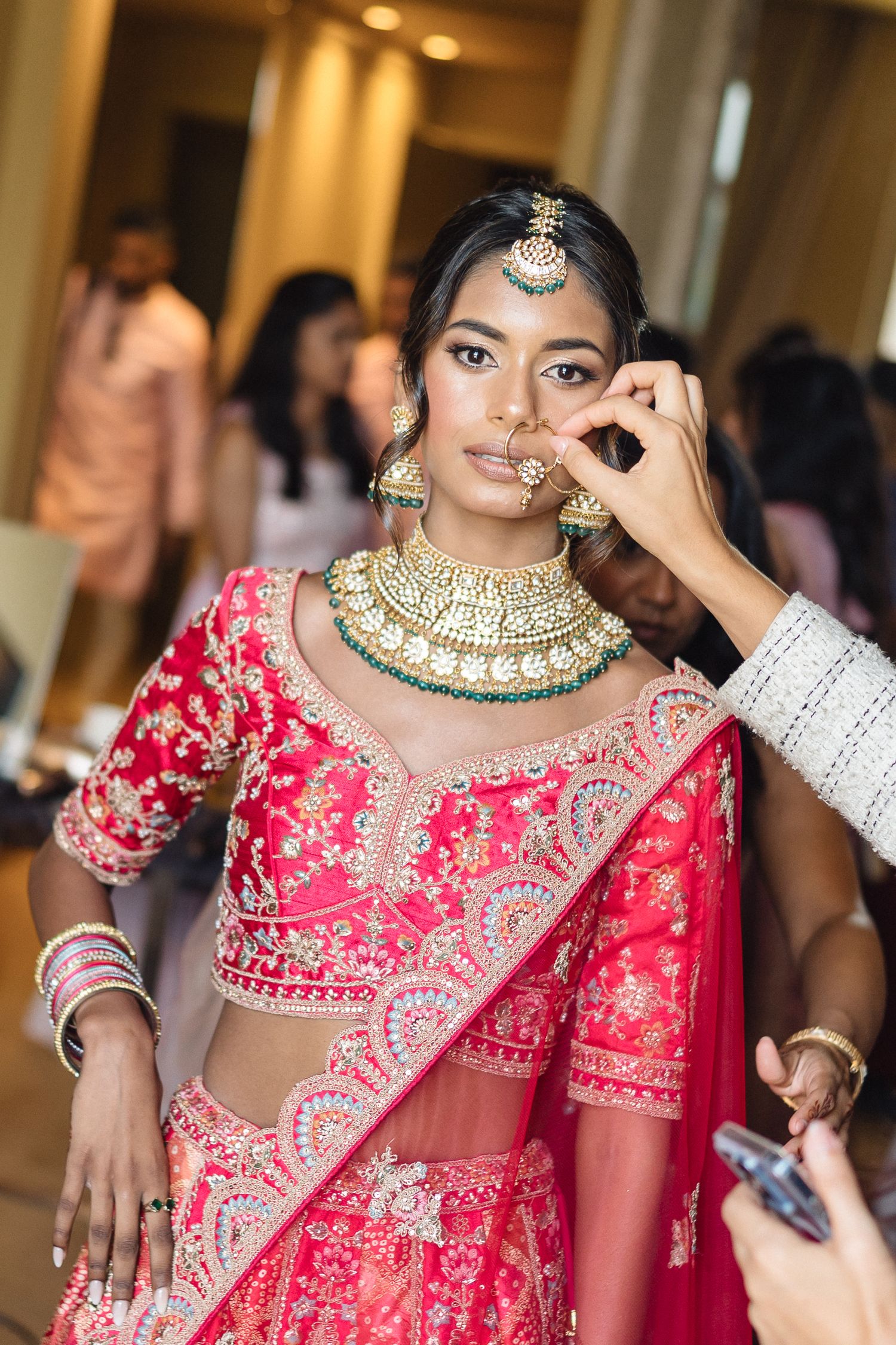 Traditional Indian bridal makeup and jewelry preparation in progress.