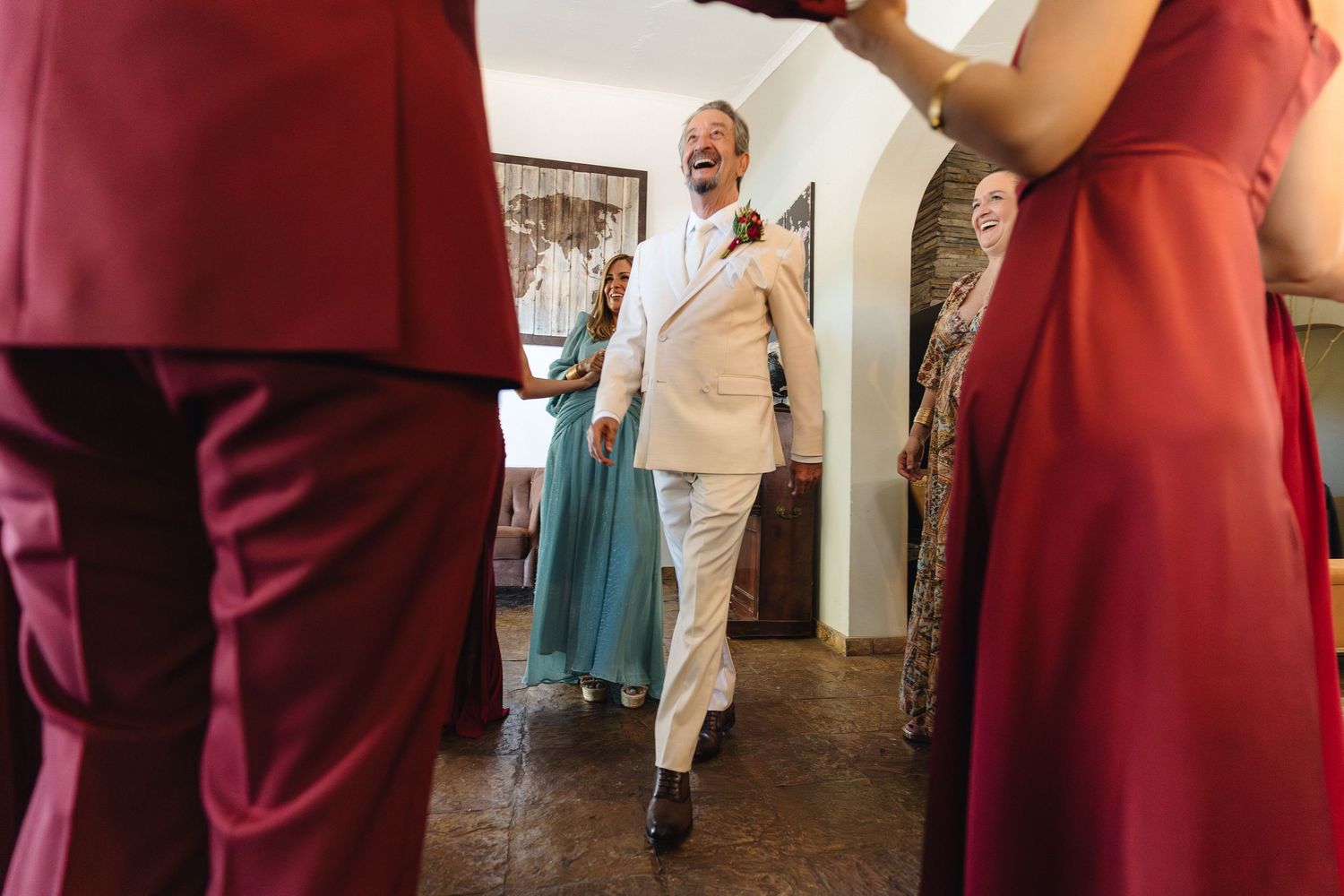 People in burgundy and formal attire gathering in an indoor setting.